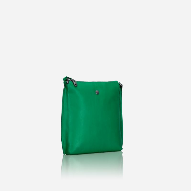 Essentials Crossbody bag in vibrant Spring Basil leather, showcasing its stylish design and adjustable strap.