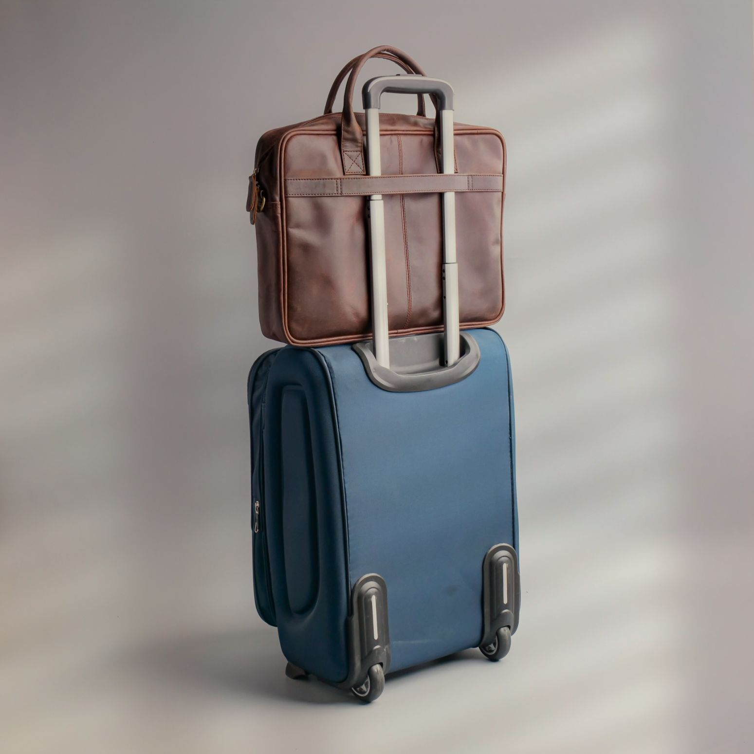 Tan brown leather laptop bag with vintage two-tone design, featuring adjustable shoulder strap and multiple compartments.