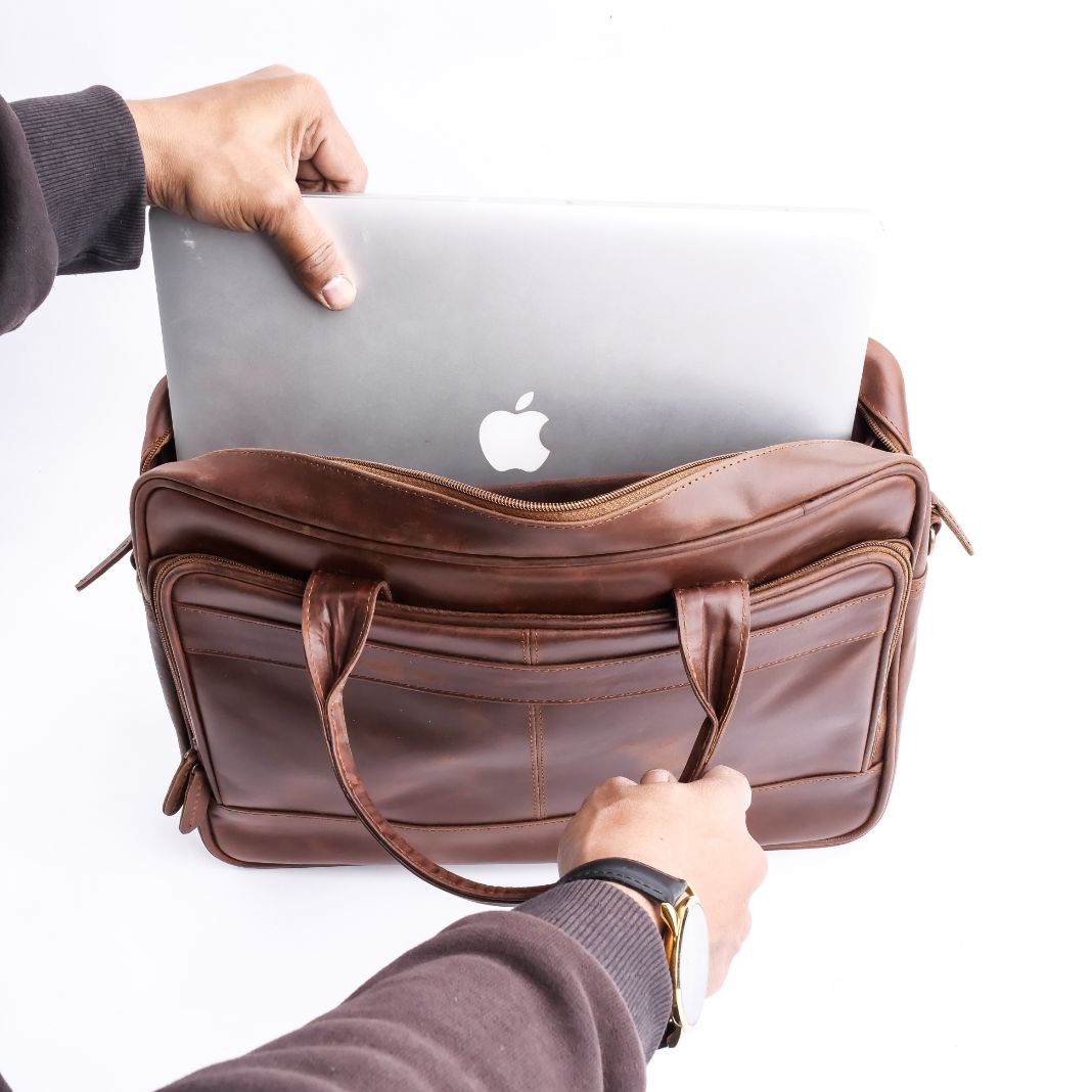 Tan brown leather laptop bag with vintage two-tone design, featuring adjustable shoulder strap and multiple compartments.