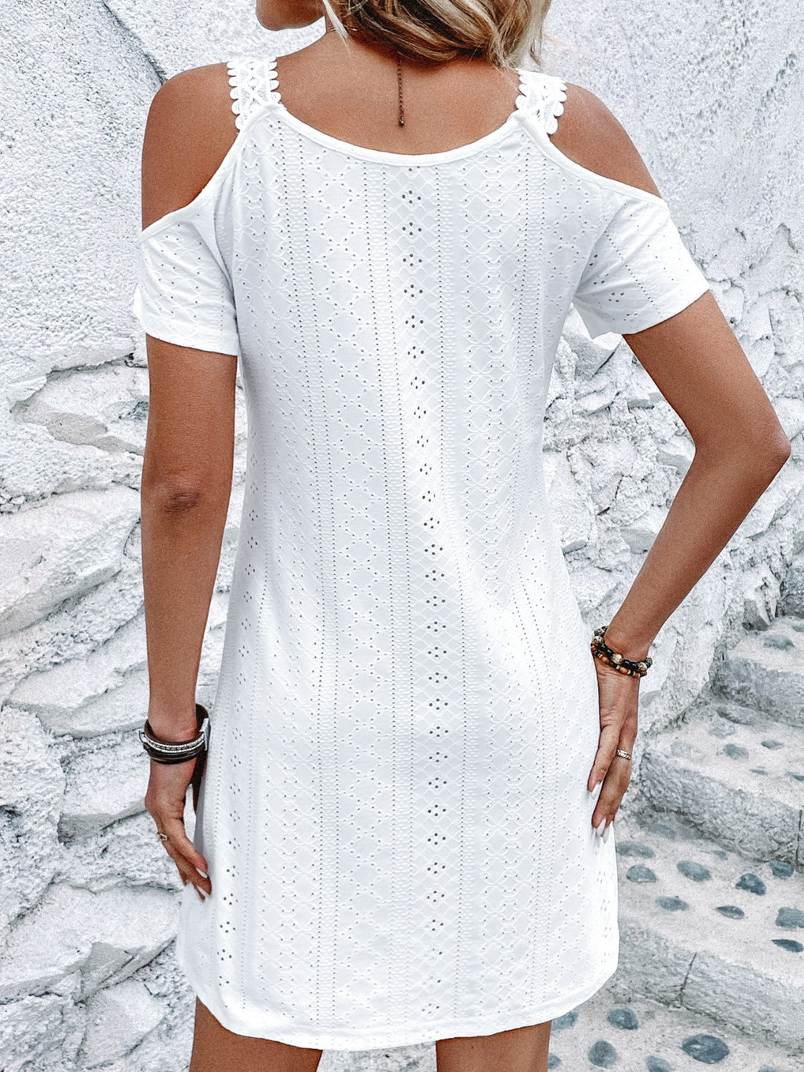 A stylish Eyelet V-Neck Cold Shoulder Mini Dress featuring eyelet detailing and a slightly stretchy fit, perfect for summer outings.