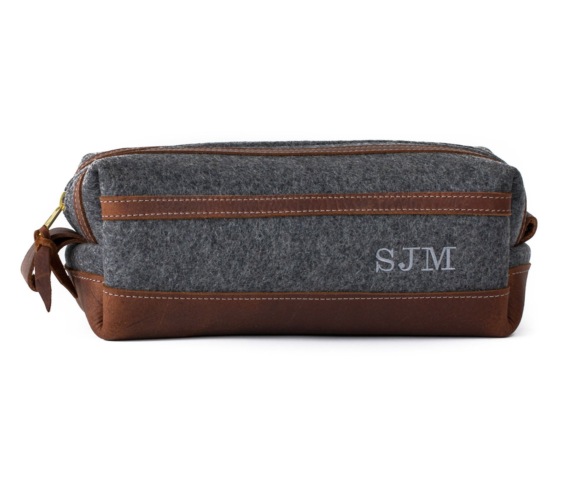 Stylish felt and leather toiletry bag with brass zippers and water-resistant liner, showcasing its unique design and personalization option.