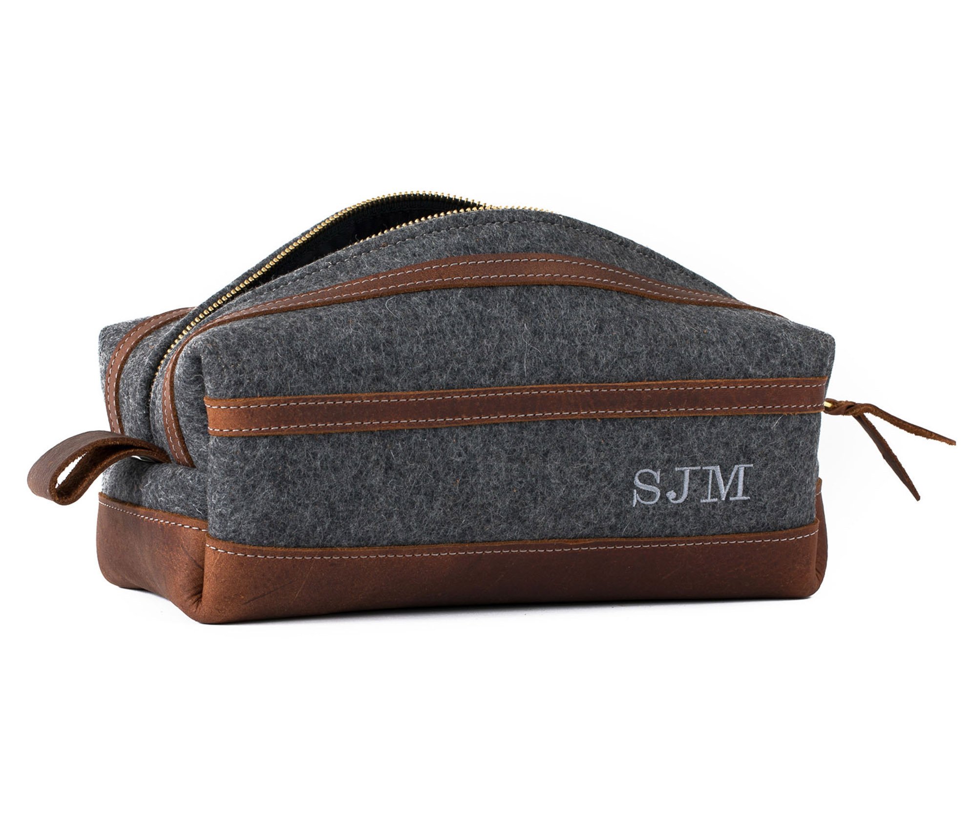 Stylish felt and leather toiletry bag with brass zippers and water-resistant liner, showcasing its unique design and personalization option.