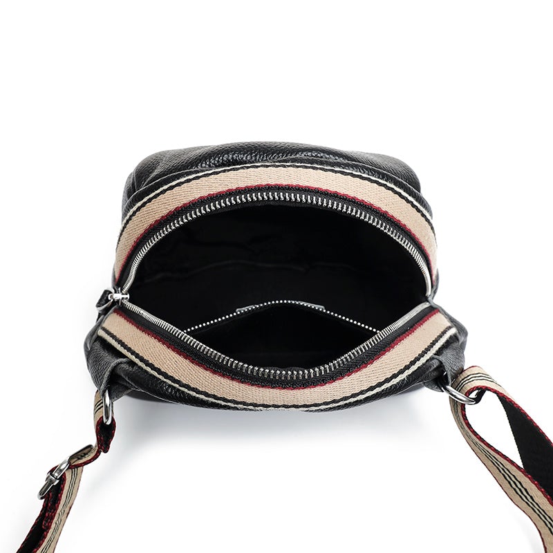 Female shell shape one-shoulder messenger bag made of PU leather with a zipper closure and single shoulder strap.