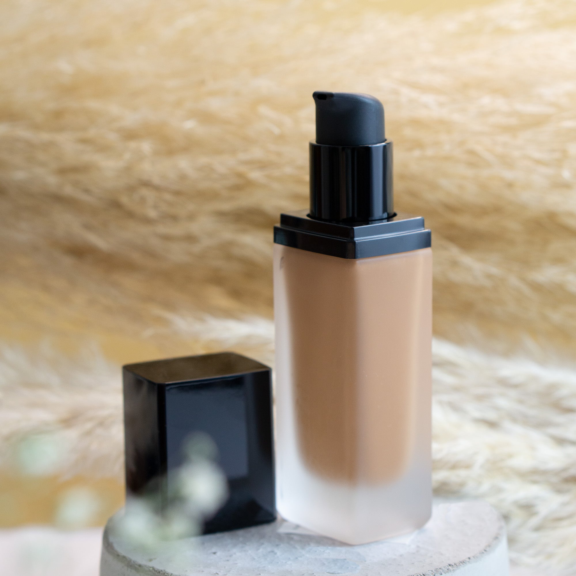 A bottle of Foundation with SPF - Bronze Night showcasing its sleek design and rich bronze color, perfect for achieving a natural glow.