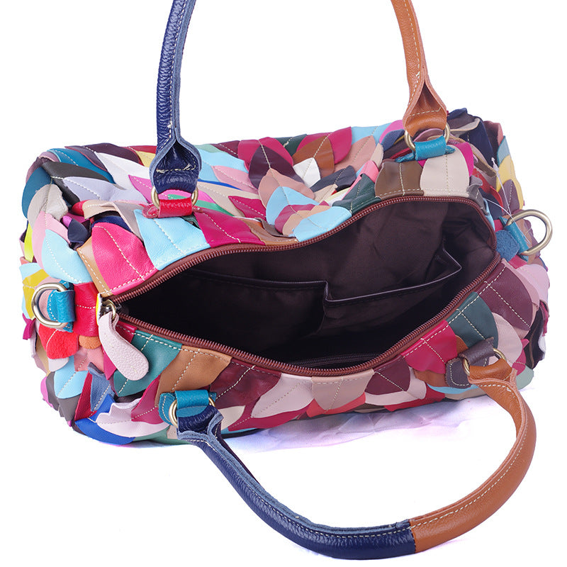 A stylish women's handbag featuring a geometric pattern and contrast colors, designed for modern use.