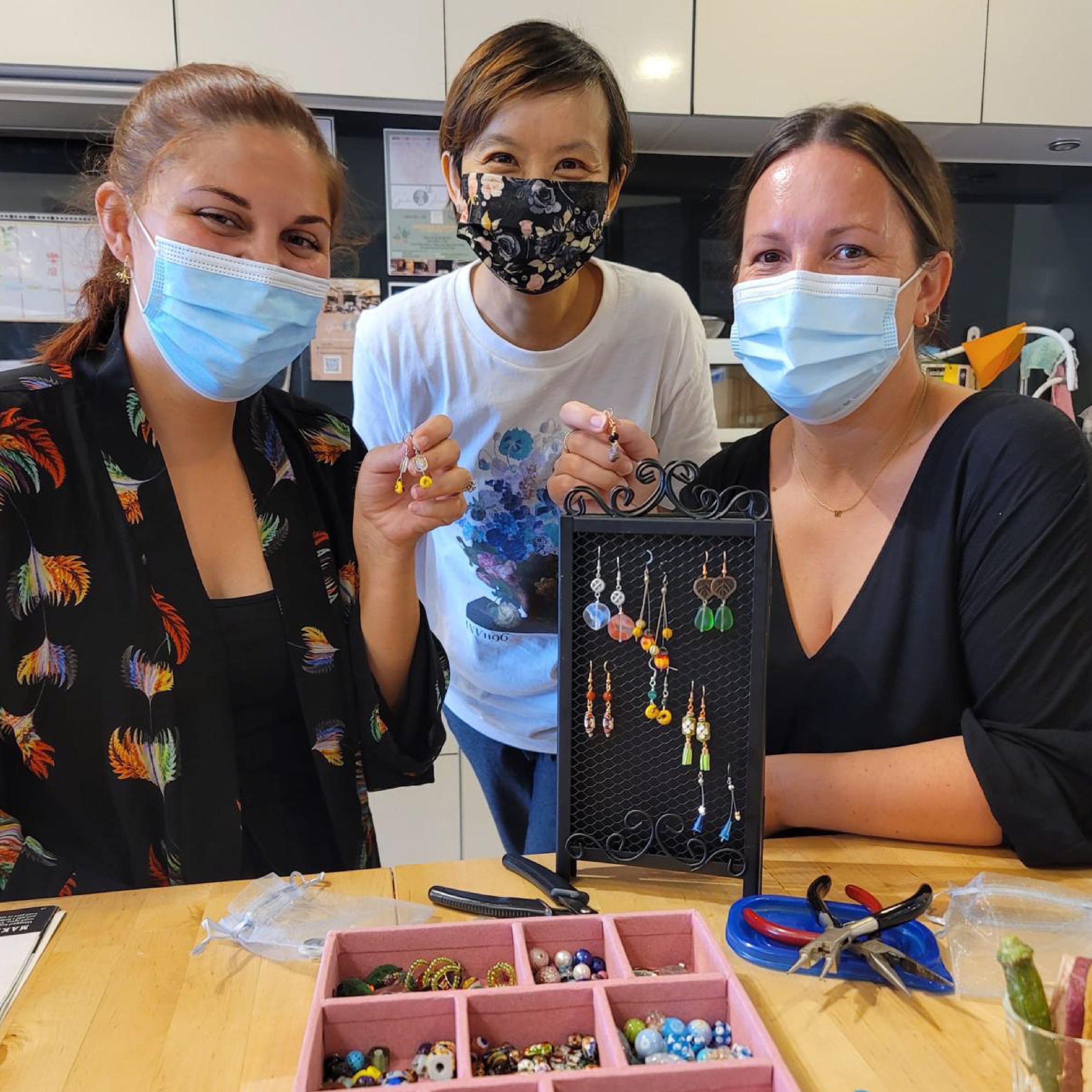 Participants creating unique handcrafted earrings with semi-precious gemstones and glass beads at La Paz HK workshop.