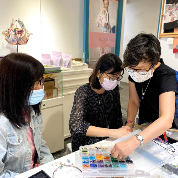 Participants creating unique handcrafted earrings with semi-precious gemstones and glass beads at La Paz HK workshop.