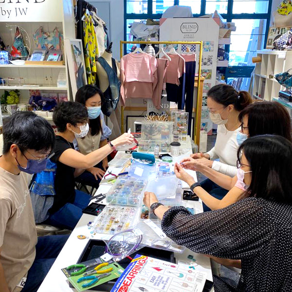 Participants creating unique handcrafted earrings with semi-precious gemstones and glass beads at La Paz HK workshop.