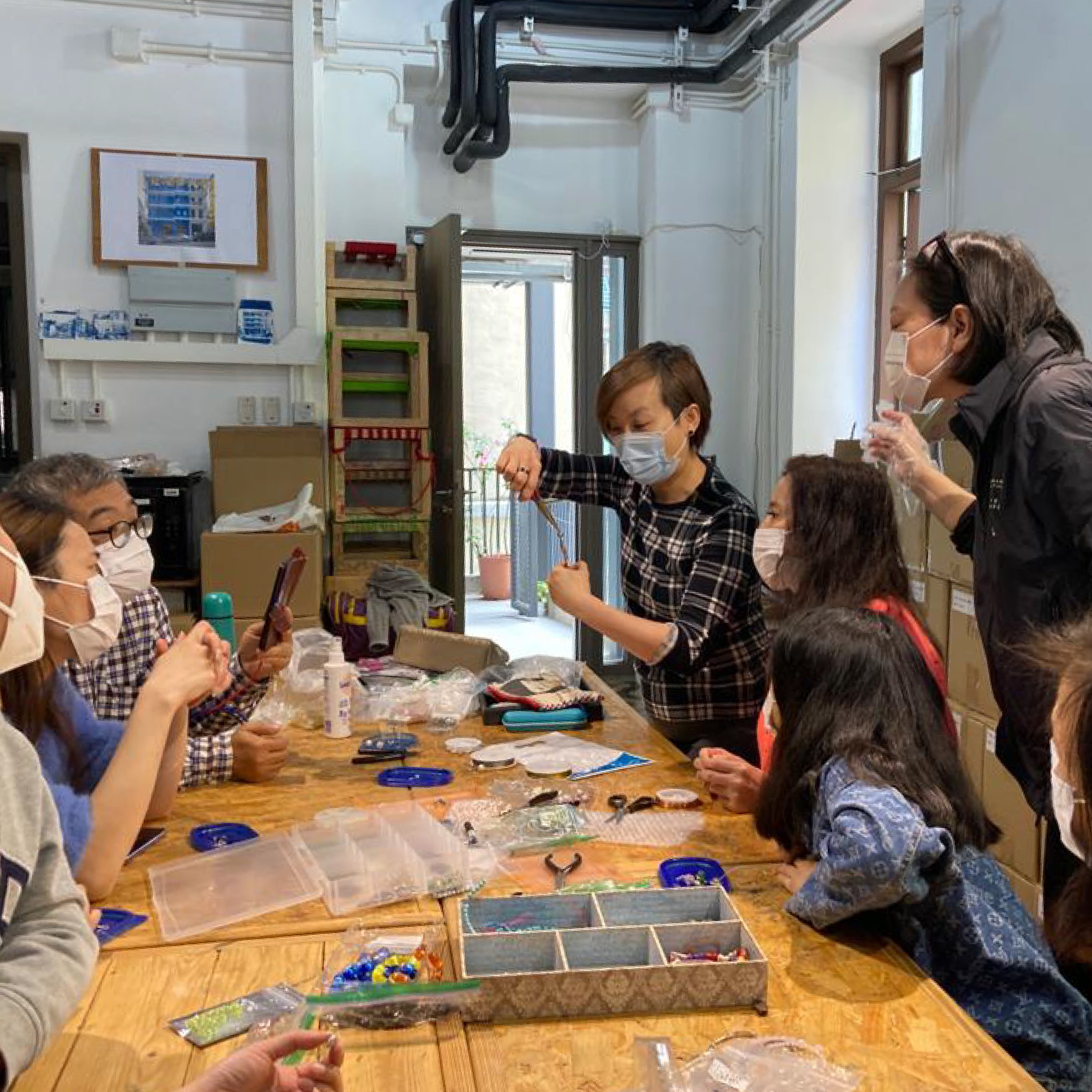 Participants creating unique handcrafted earrings with semi-precious gemstones and glass beads at La Paz HK workshop.