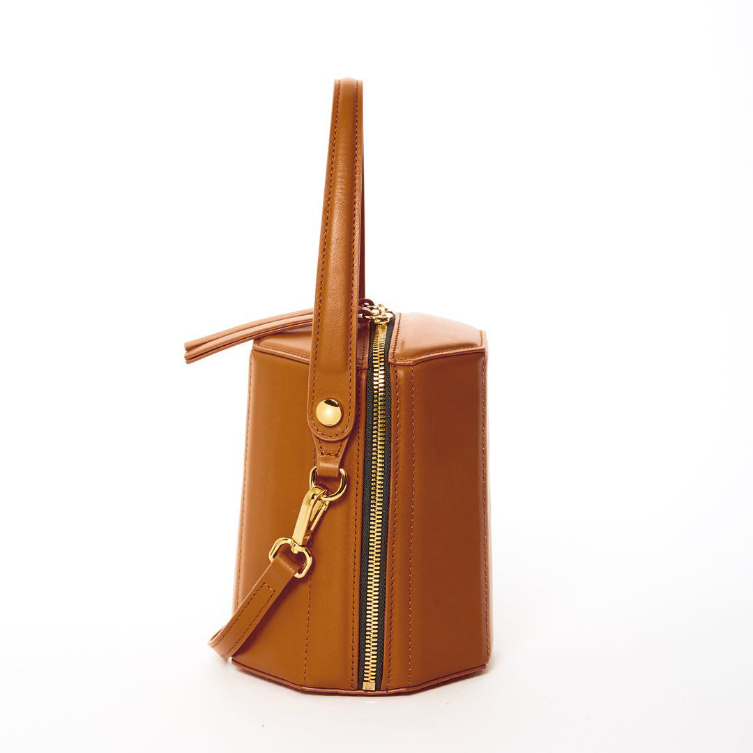 Harper Amber Brown Leather Bucket Bag featuring gold hardware and a unique geometric shape, perfect for stylish outings.