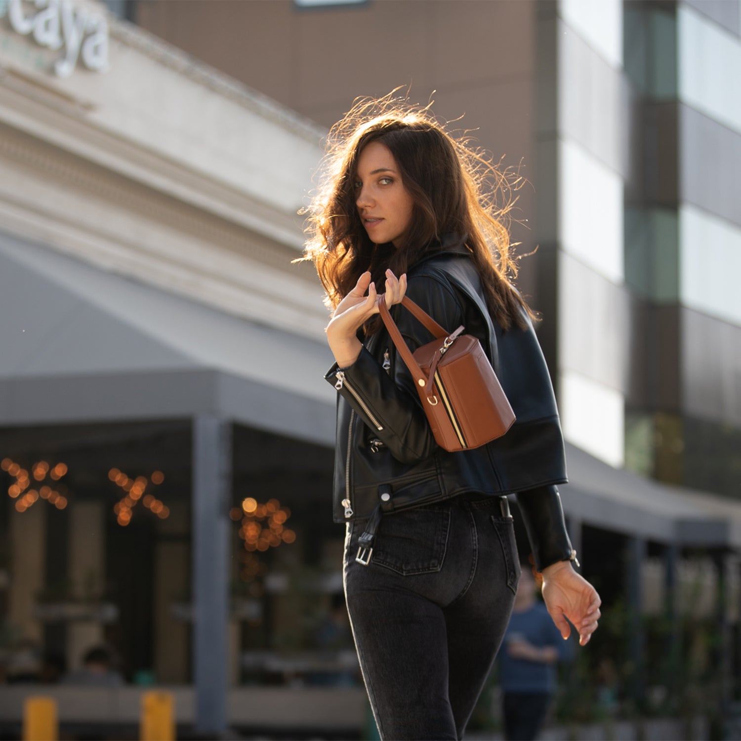 Harper Amber Brown Leather Bucket Bag featuring gold hardware and a unique geometric shape, perfect for stylish outings.