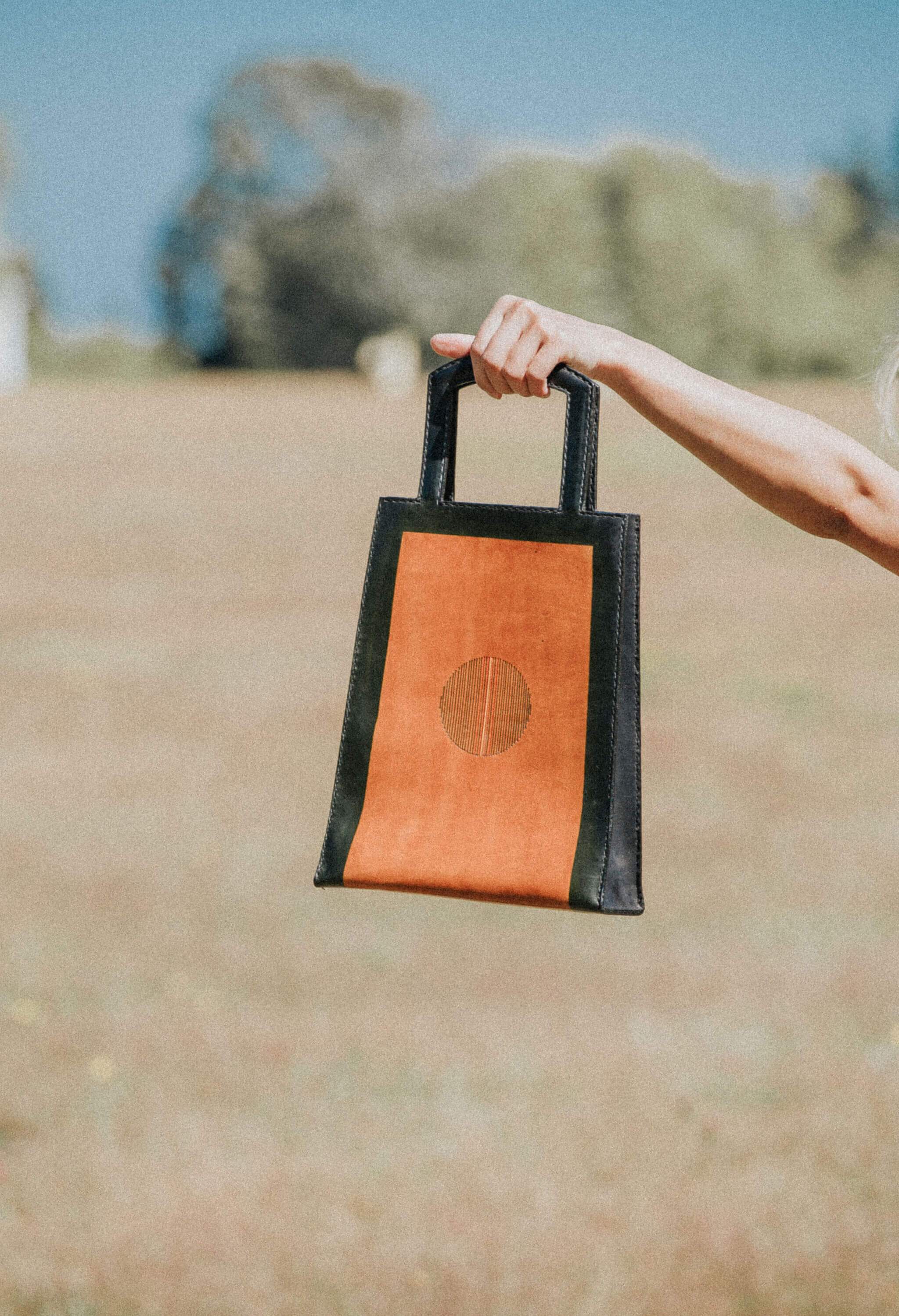 A stylish IGNIS Tote made from 100% natural vegetable-tanned leather, showcasing its unique design inspired by fire and sand.