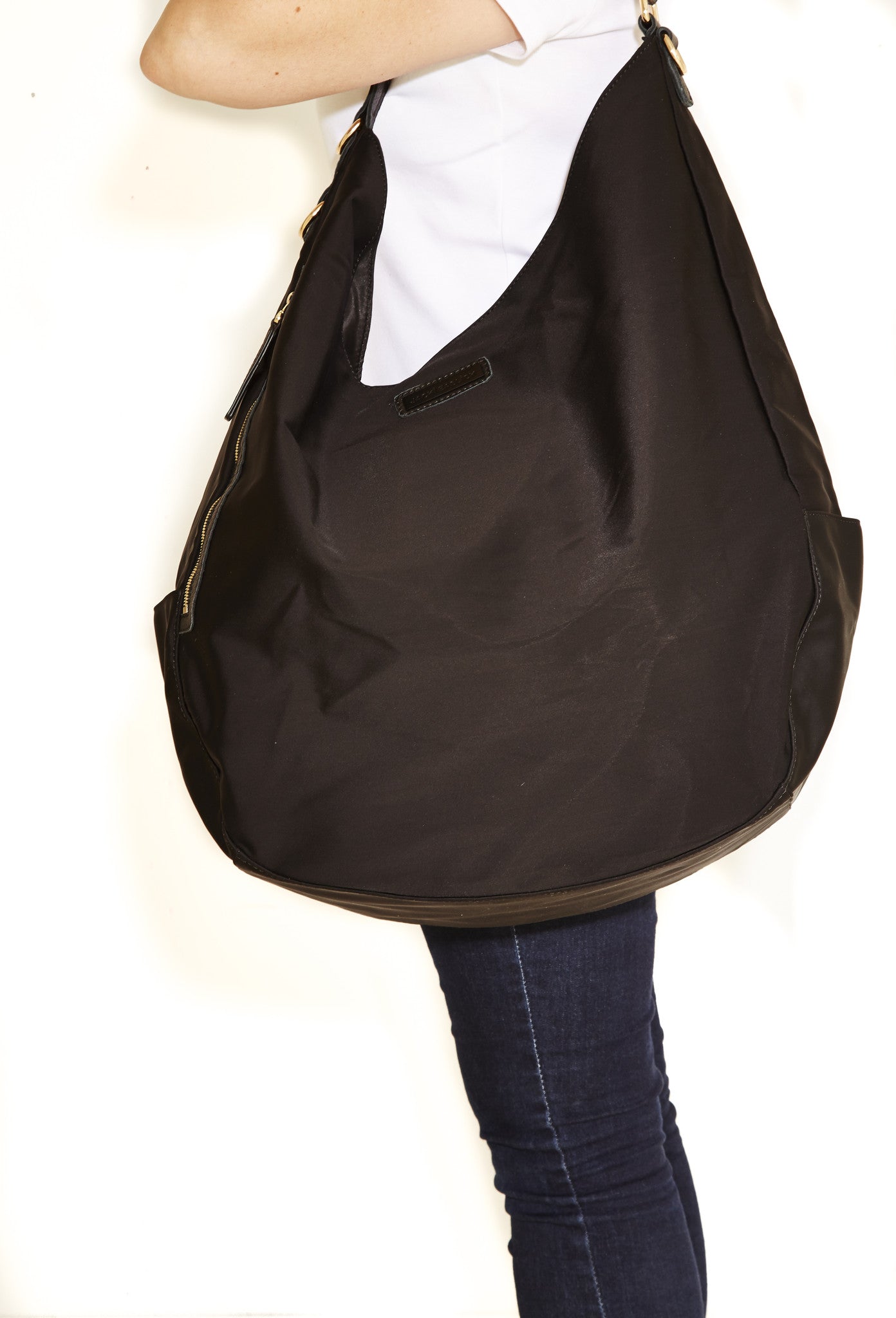 Jacki Easlick Black oversized hobo bag featuring cowhide leather trim and waterproof nylon material, ideal for travel and everyday use.