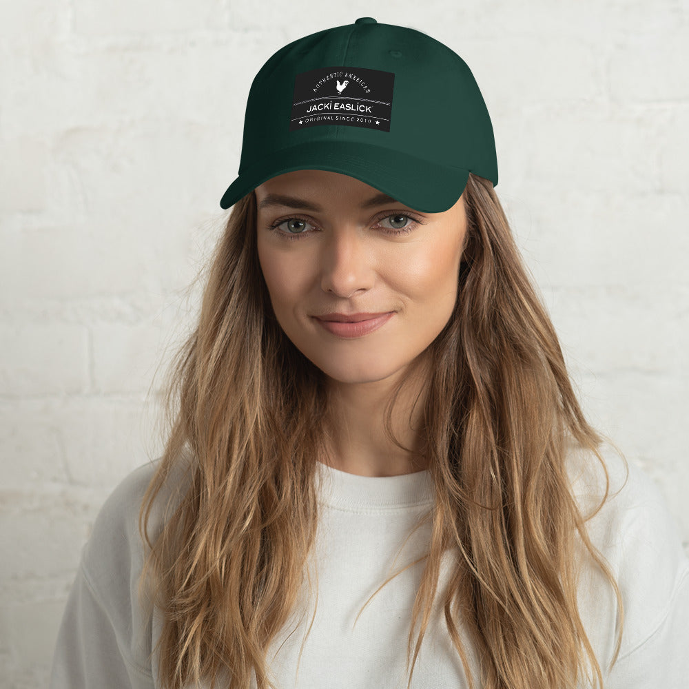 Jacki Easlick Embroidered Logo Hat in Green Camo with adjustable strap and curved visor, showcasing embroidered eyelets.