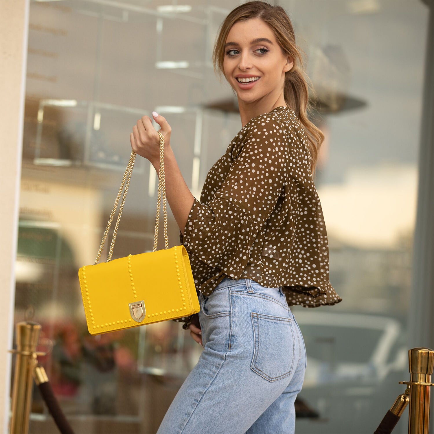 Josie Mustard Yellow Leather Purse with decorative studs and gold chain strap, showcasing its stylish design and functional features.