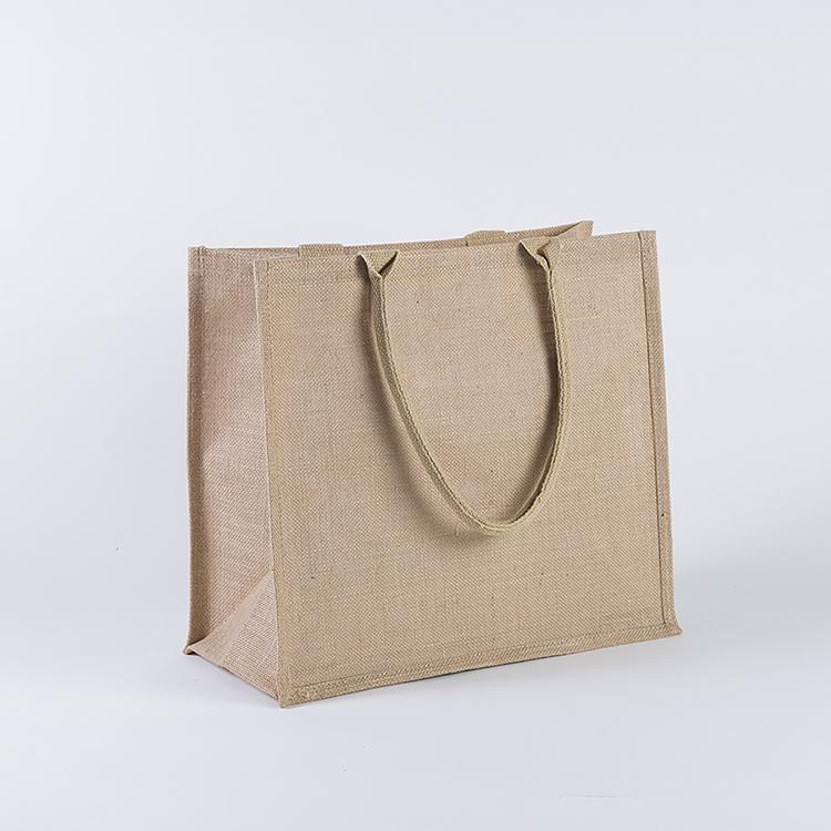 A stylish jute market bag with long handles, showcasing its rustic design and laminated interior.