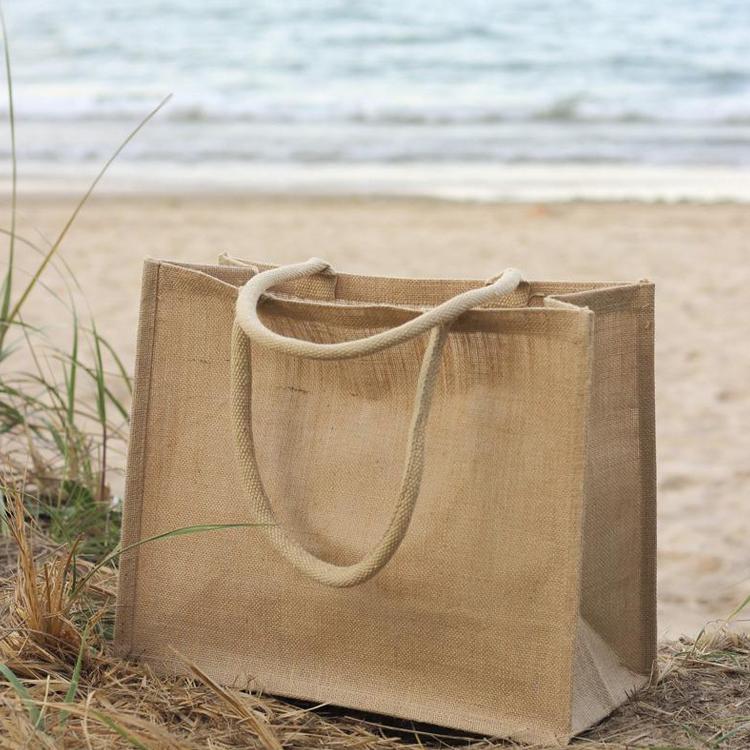 A stylish jute market bag with long handles, showcasing its rustic design and laminated interior.