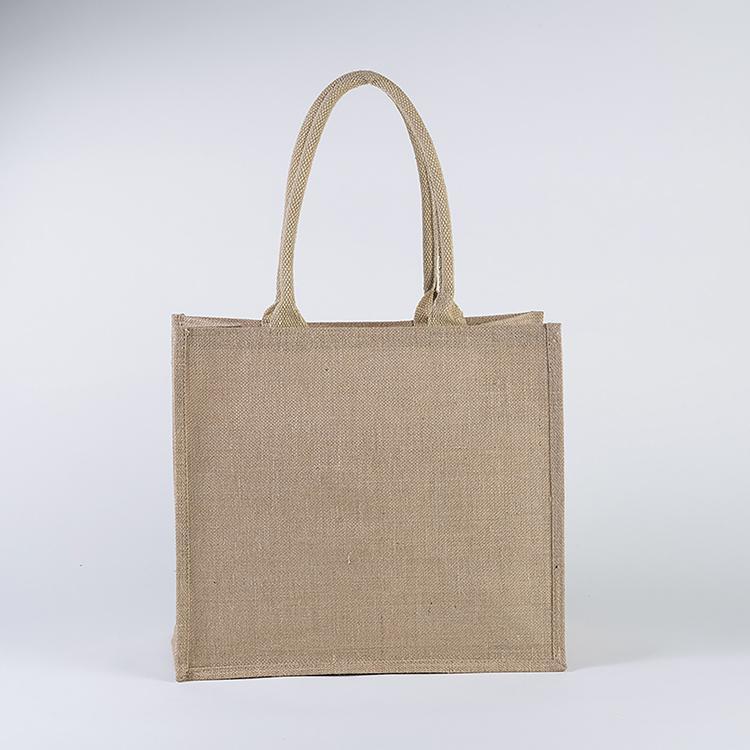 A stylish jute market bag with long handles, showcasing its rustic design and laminated interior.