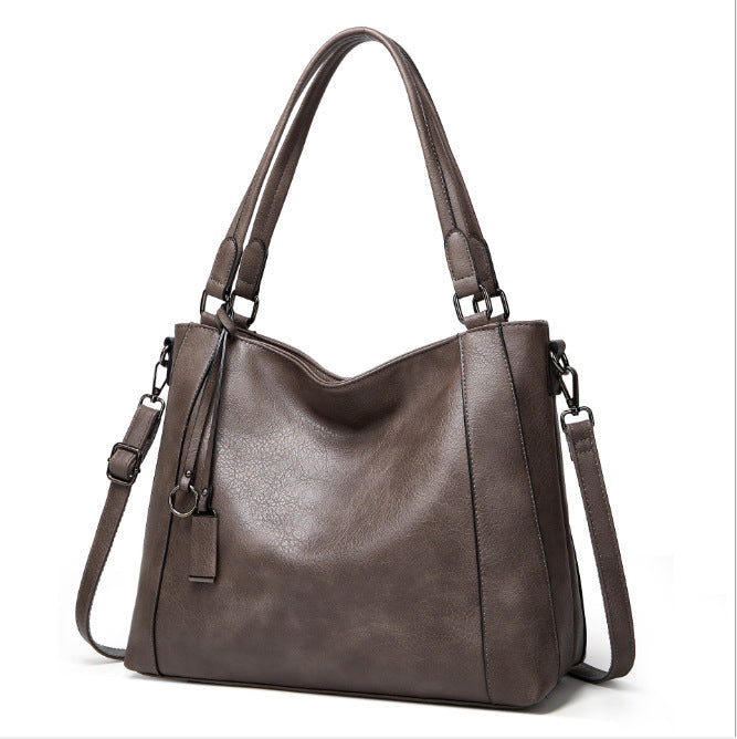 Ladies Soft Leather Portable Fashion Casual Messenger Bag in soft PU leather with a bucket shape and zipper opening, featuring multiple internal pockets.