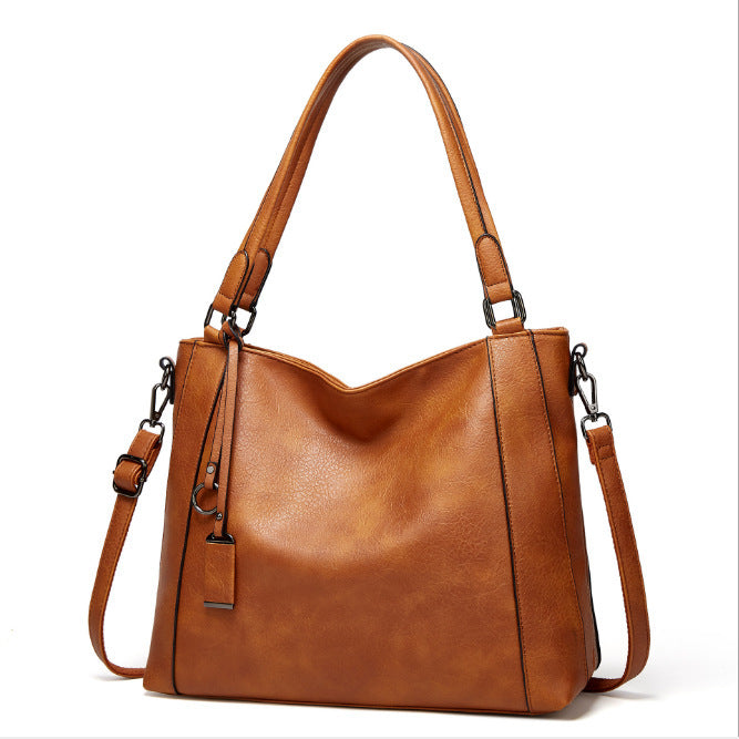 Ladies Soft Leather Portable Fashion Casual Messenger Bag in soft PU leather with a bucket shape and zipper opening, featuring multiple internal pockets.