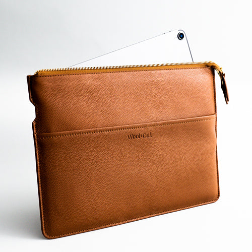 Wool & Oak 13" laptop sleeve with padded compartment and quick charge slot, featuring three exterior pockets for office essentials.