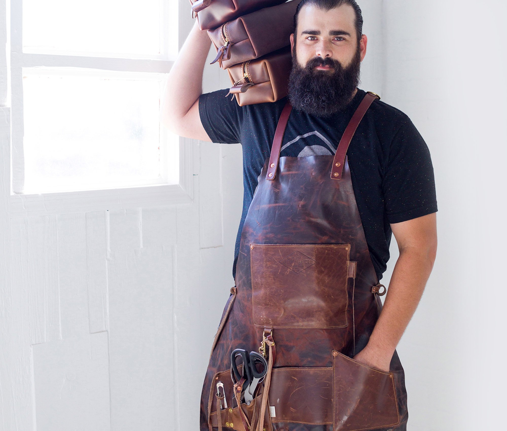 A handcrafted genuine leather apron featuring multiple pockets and personalization options, showcasing its rich texture and durability.