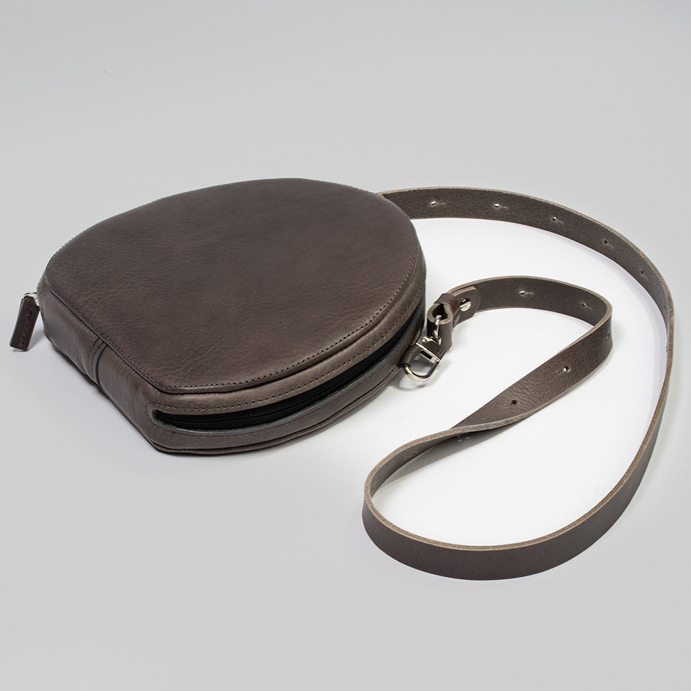 Brown leather case for AirPods Max, crafted from full-grain Italian leather with a soft lining and adjustable strap loops.