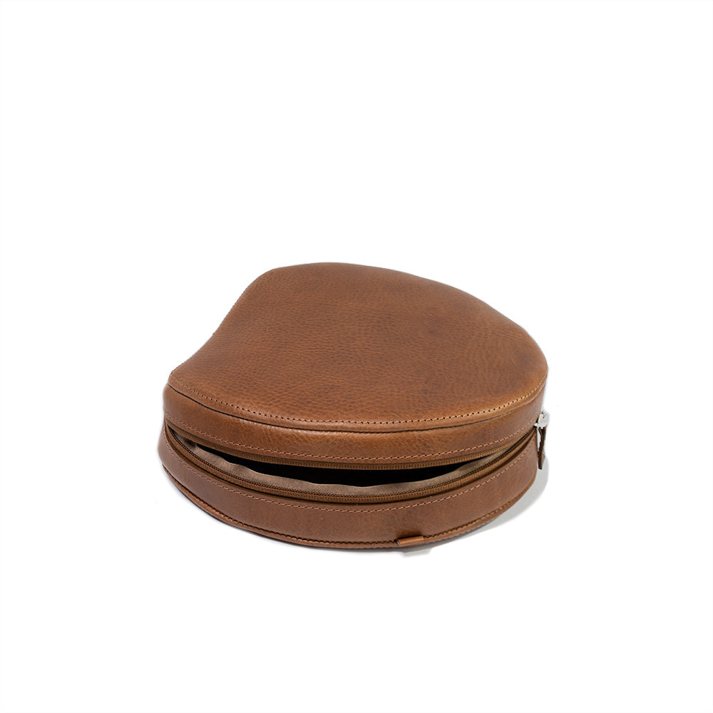 Brown leather case for AirPods Max, crafted from full-grain Italian leather with a soft lining and adjustable strap loops.