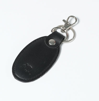 Black leather keychain featuring a silver metal hook and key ring with thread stitching and JILD logo embossing.