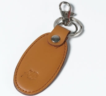 Camel brown leather keychain with silver metal hook and ring, featuring thread stitching and JILD logo embossing.