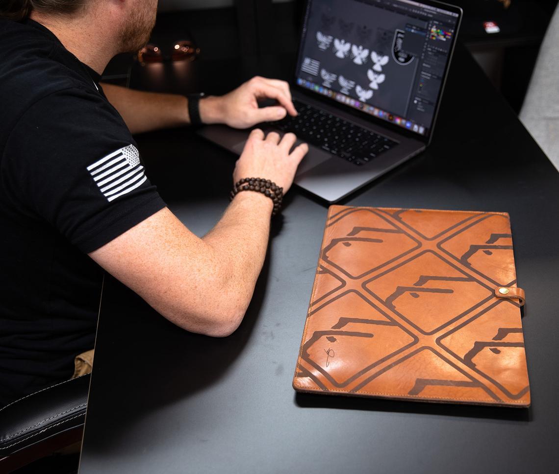 Personalized leather laptop sleeve made from genuine full grain leather, featuring a secure strap and brass snap, ideal for 13"-15" laptops.