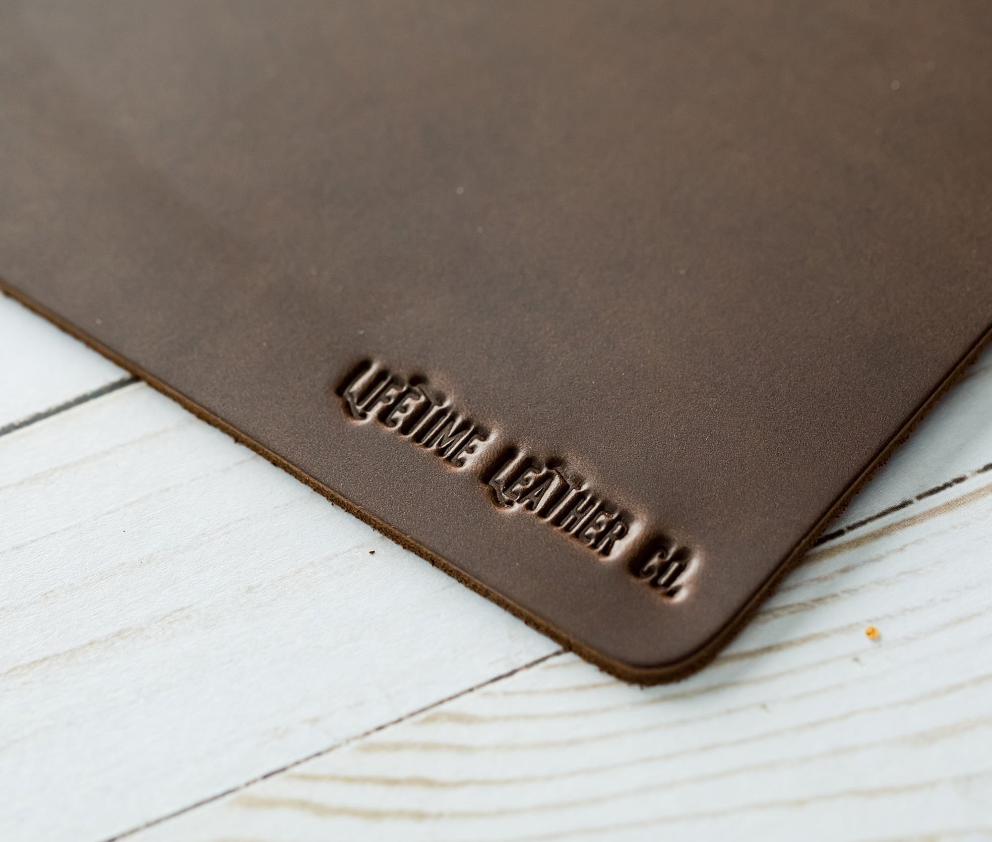 A stylish genuine full grain leather mouse pad with a smooth surface, perfect for office and gaming use.