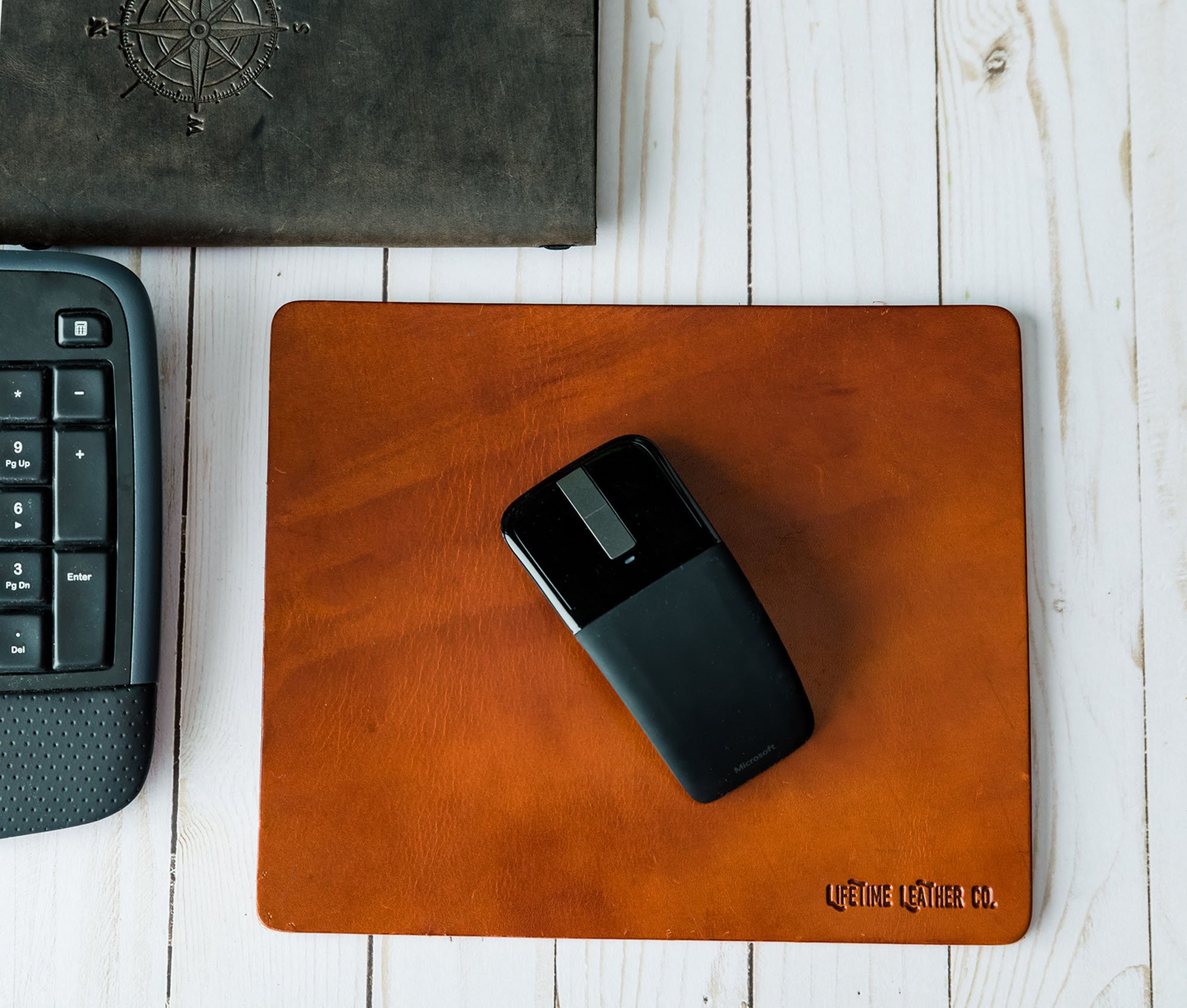 A stylish genuine full grain leather mouse pad with a smooth surface, perfect for office and gaming use.