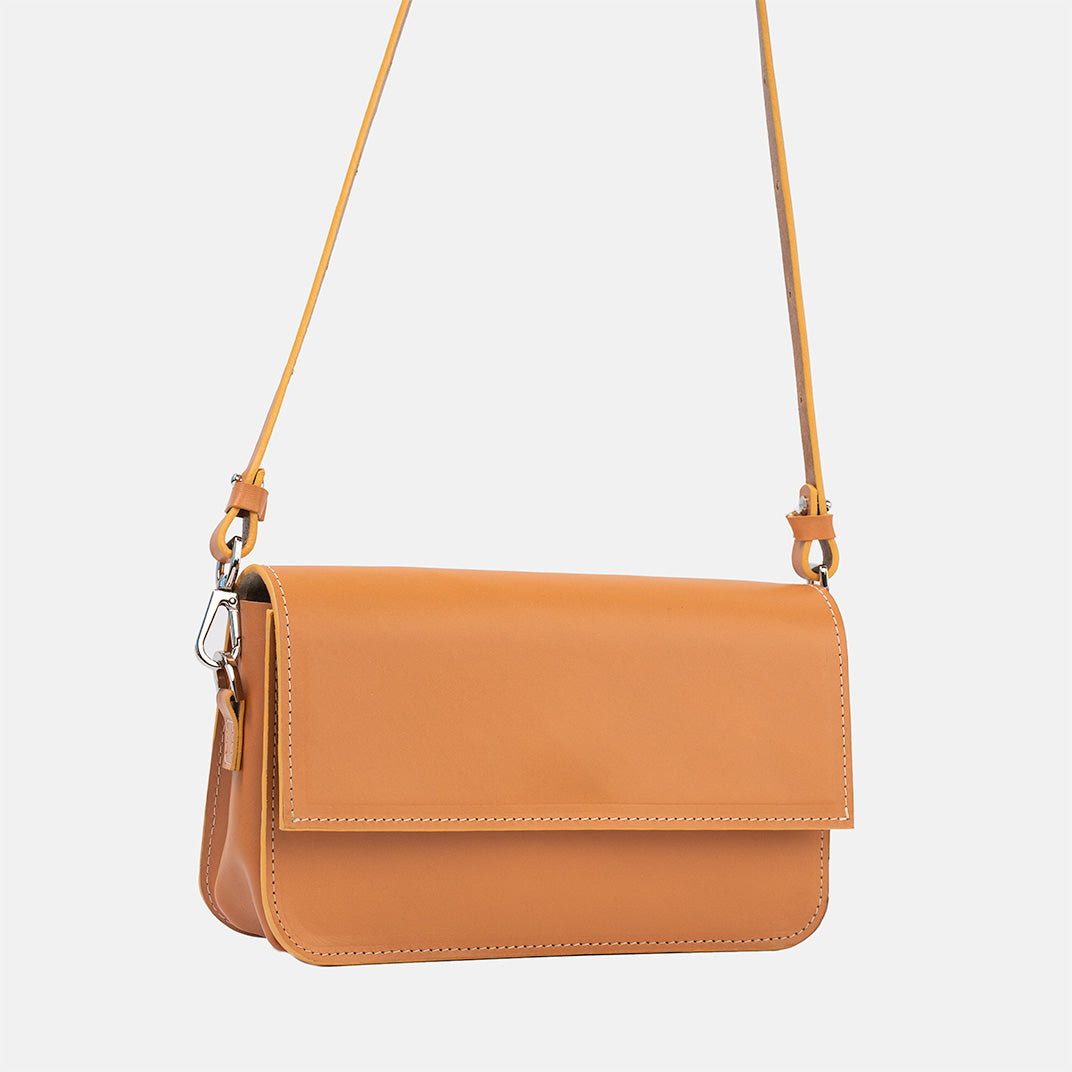 Light orange leather shoulder bag with structured design and adjustable strap, showcasing premium Italian craftsmanship.