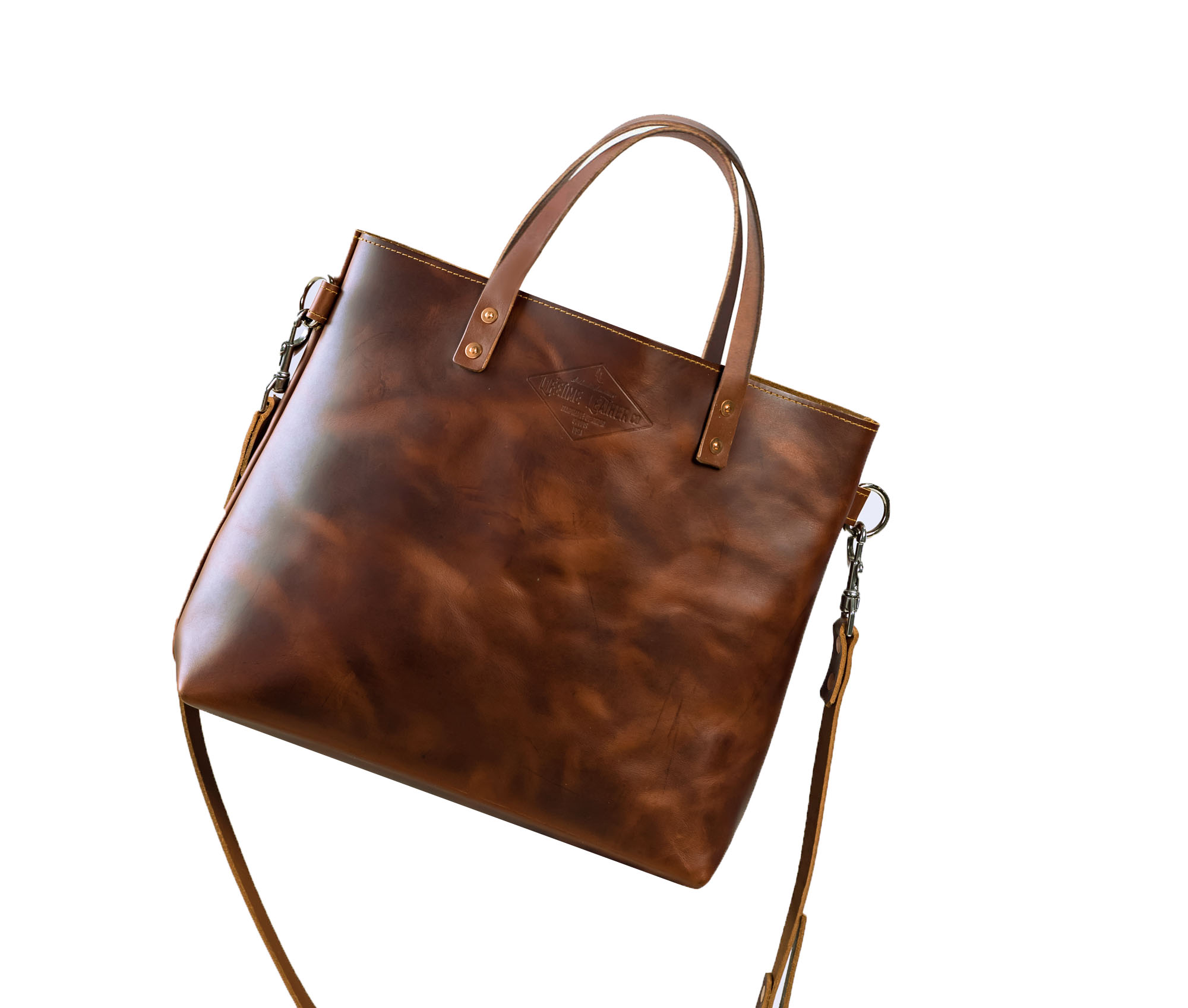 Lifetime Crossbody Tote made of full grain leather, featuring adjustable strap and spacious interior pockets.