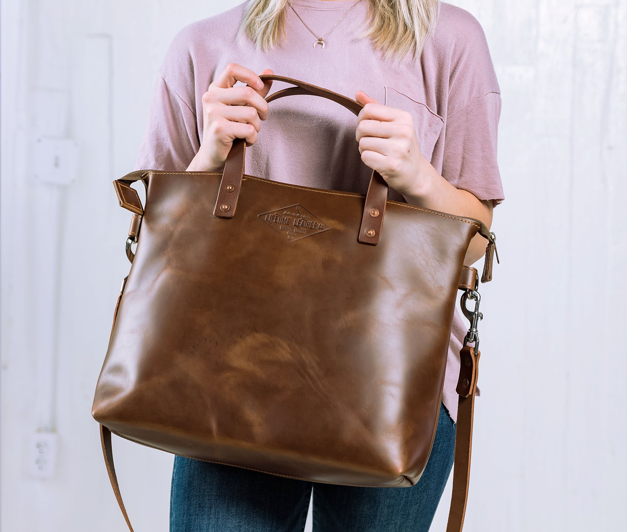 Lifetime Crossbody Tote made of full grain leather, featuring adjustable strap and spacious interior pockets.