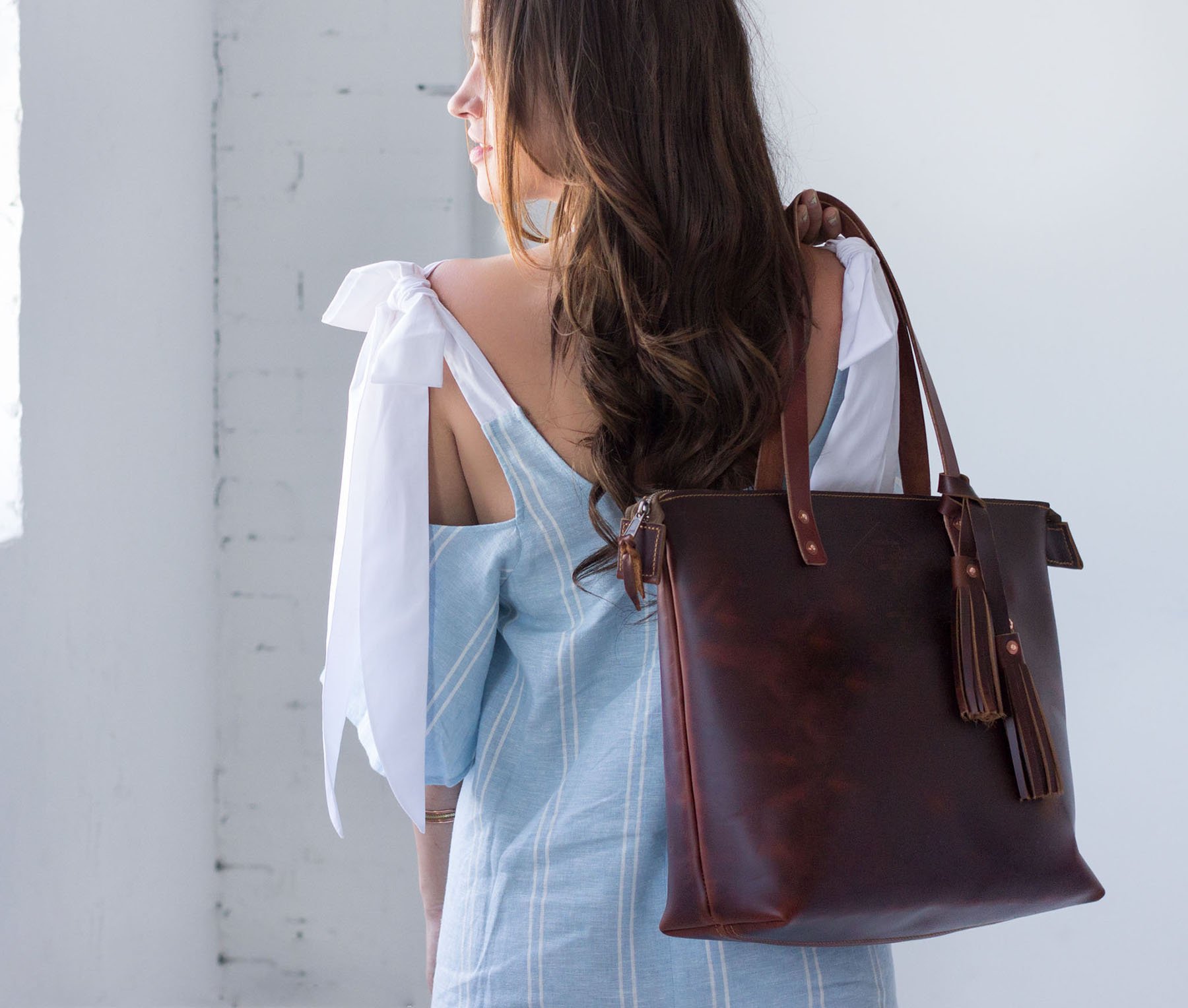 Lifetime Zippered Tote made of genuine American full grain leather, featuring a zippered top and multiple interior pockets.