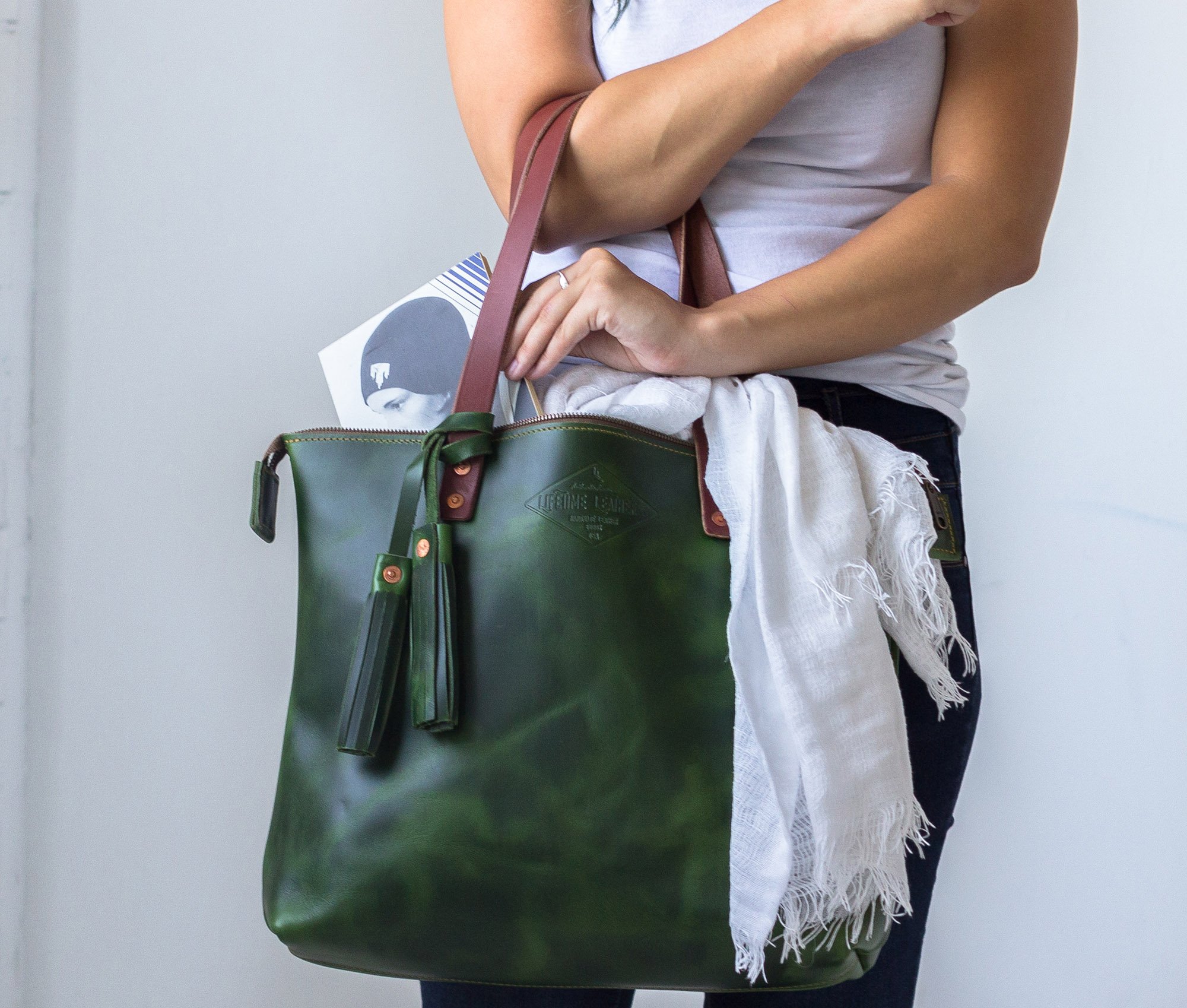 Lifetime Zippered Tote made of genuine American full grain leather, featuring a zippered top and multiple interior pockets.