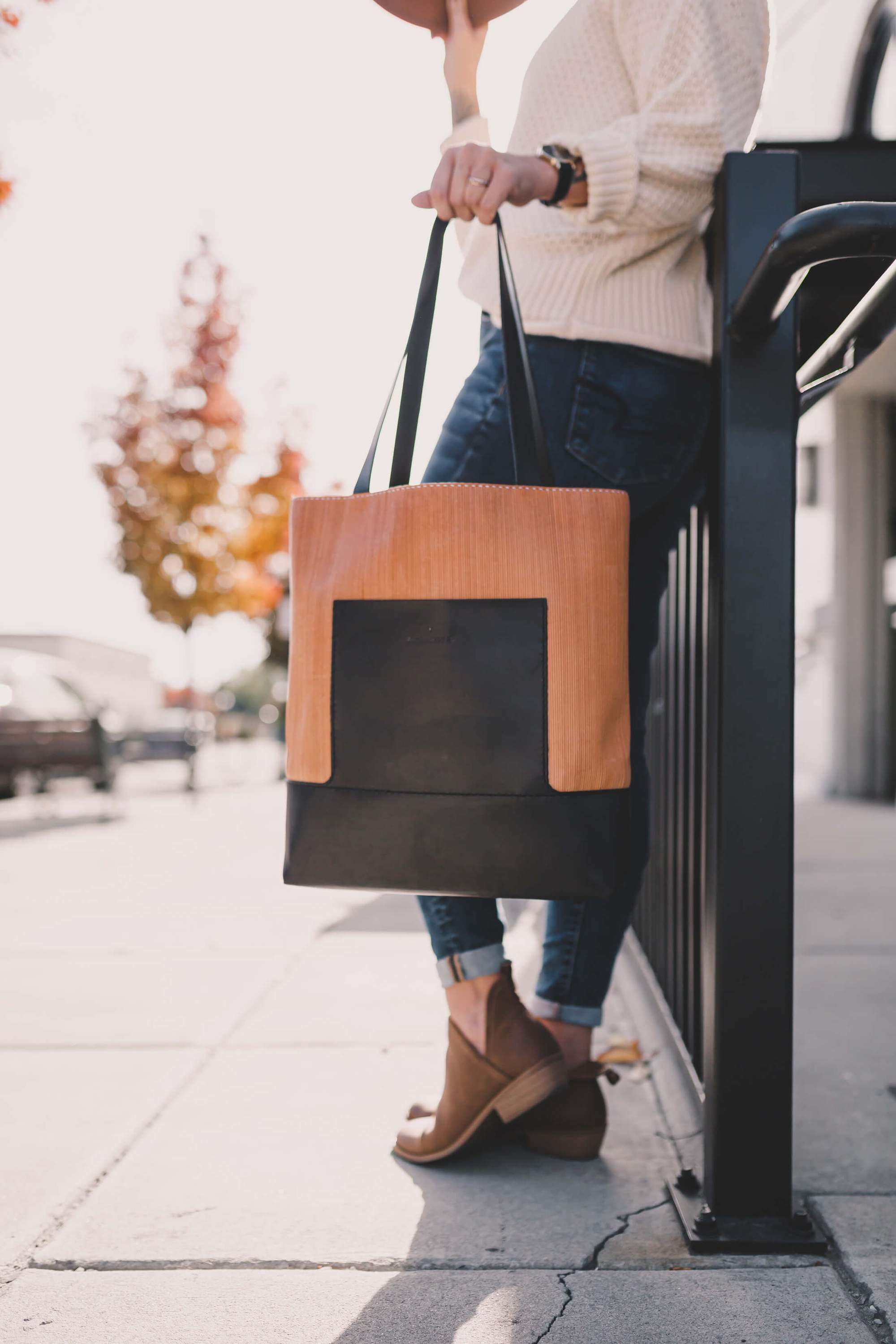 Linéaire Tote bag made of natural Veg Tan leather with hand engraving, featuring leather shoulder straps and an exterior pocket.