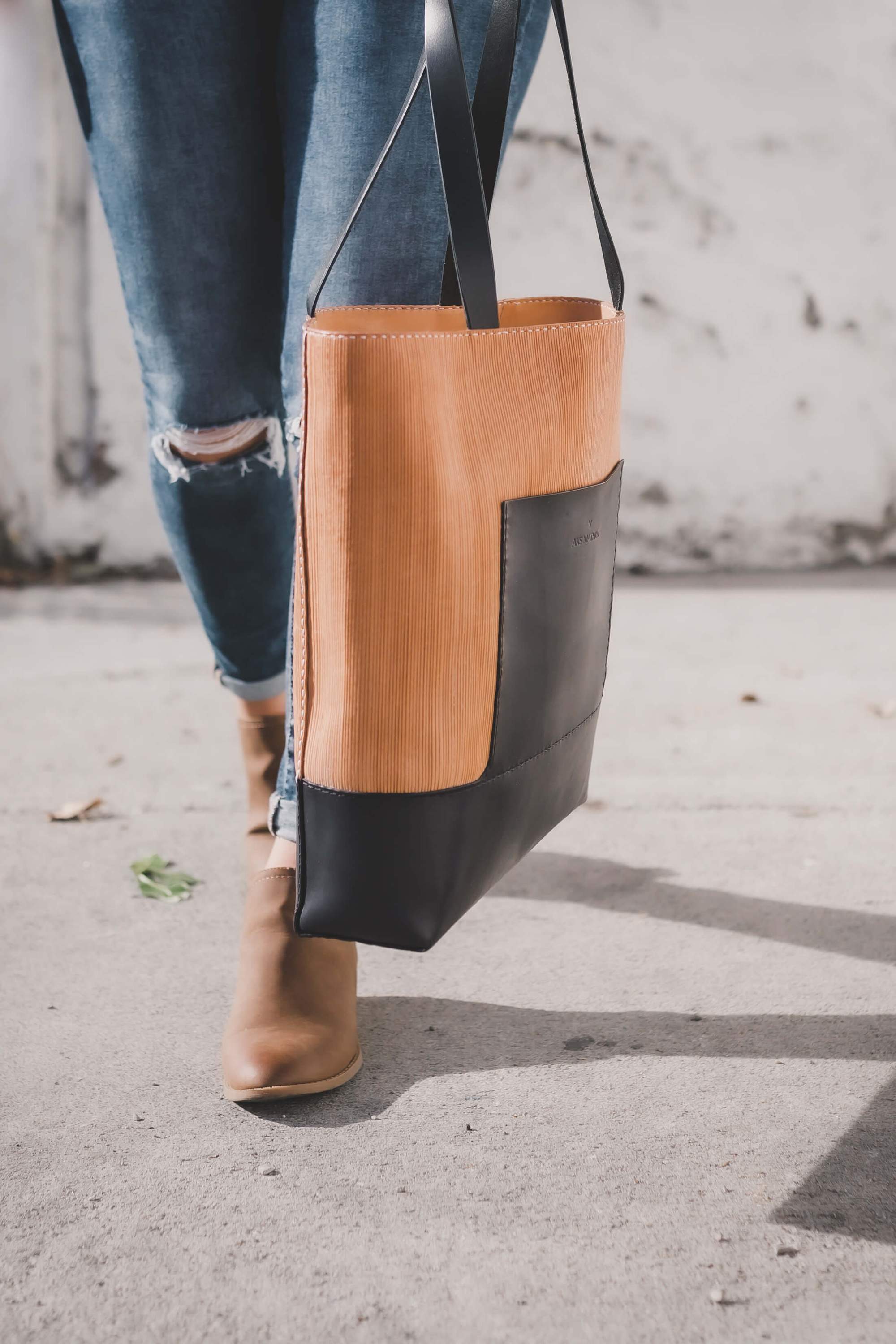 Linéaire Tote bag made of natural Veg Tan leather with hand engraving, featuring leather shoulder straps and an exterior pocket.