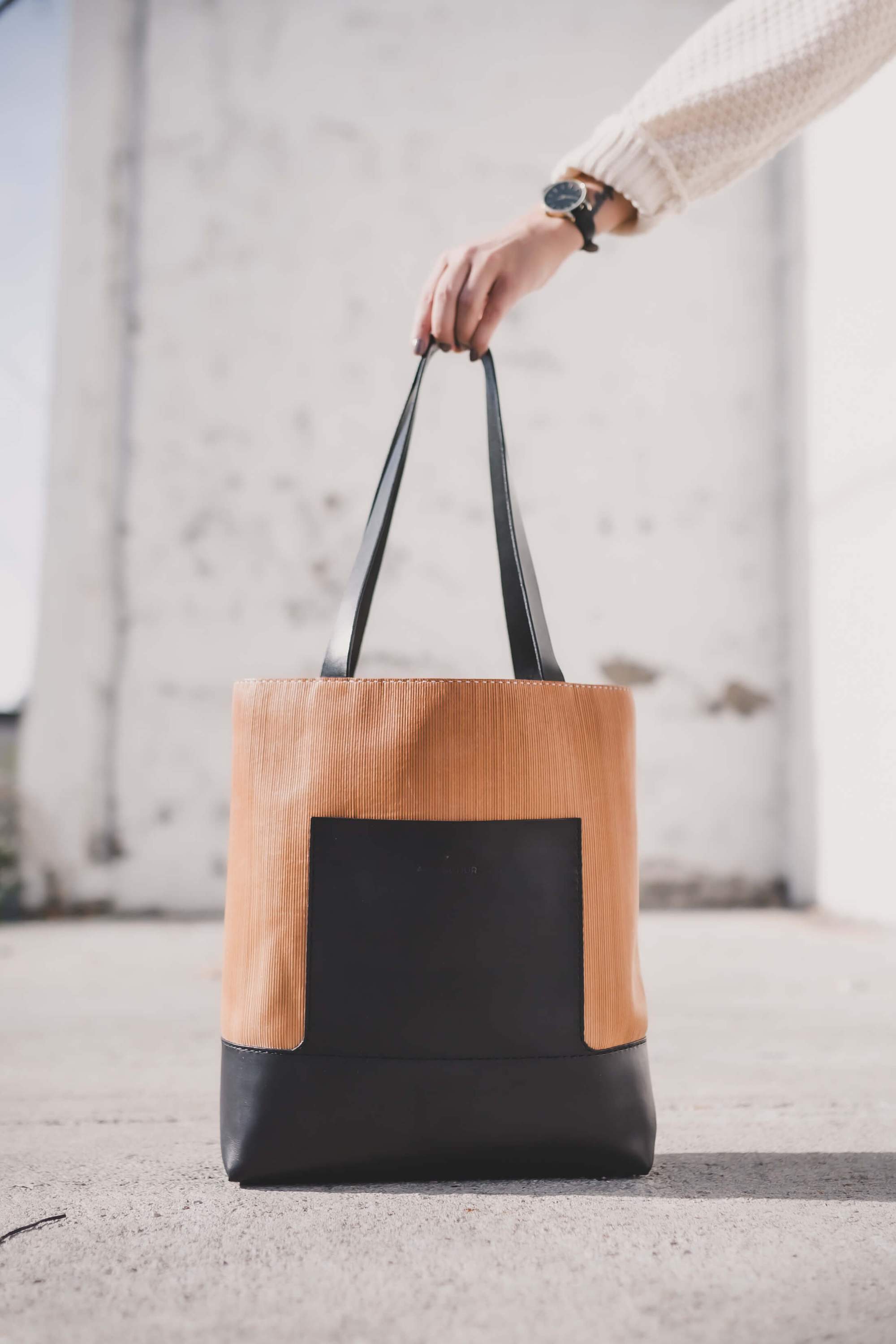 Linéaire Tote bag made of natural Veg Tan leather with hand engraving, featuring leather shoulder straps and an exterior pocket.