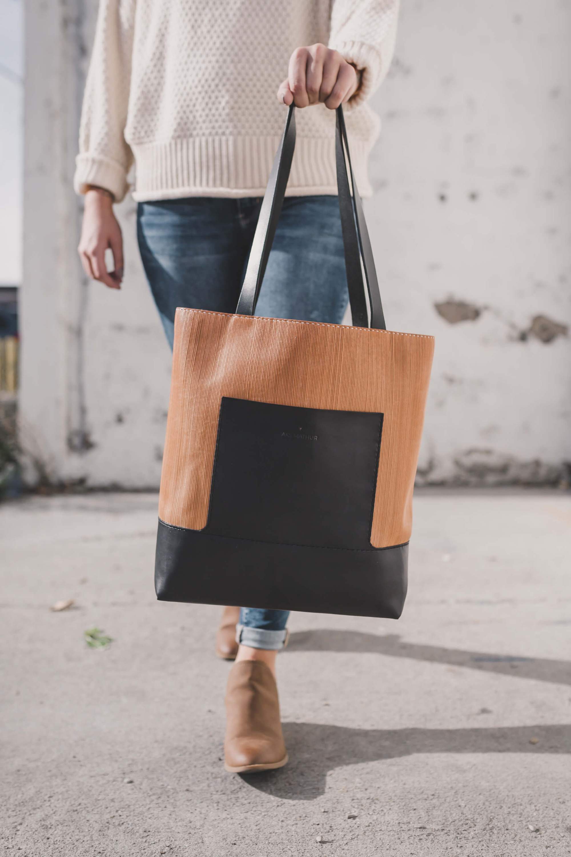 Linéaire Tote bag made of natural Veg Tan leather with hand engraving, featuring leather shoulder straps and an exterior pocket.