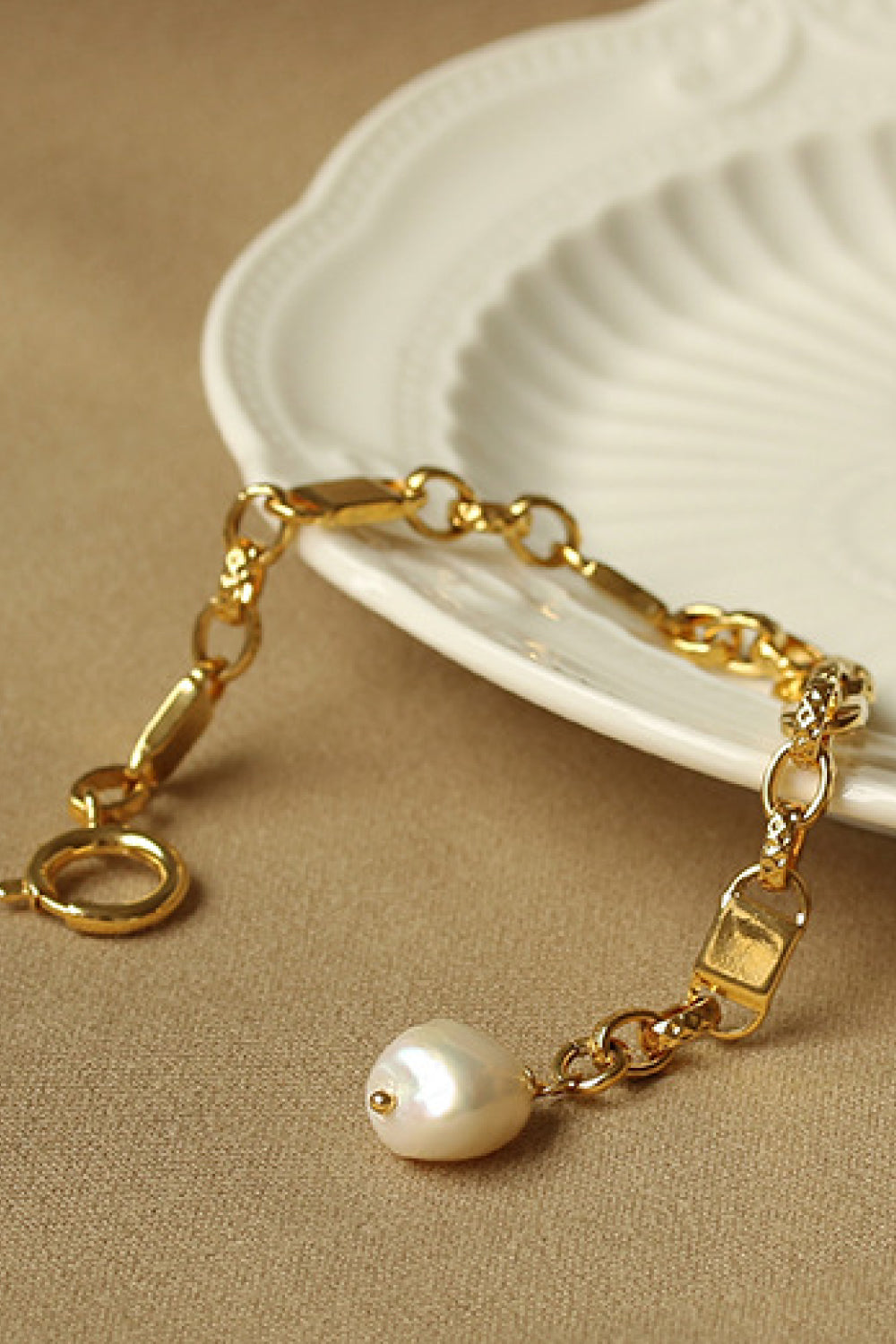 A stylish Link Chain Bracelet featuring a chunky gold plated brass chain and a delicate pearl pendant, perfect for elegant accessorizing.