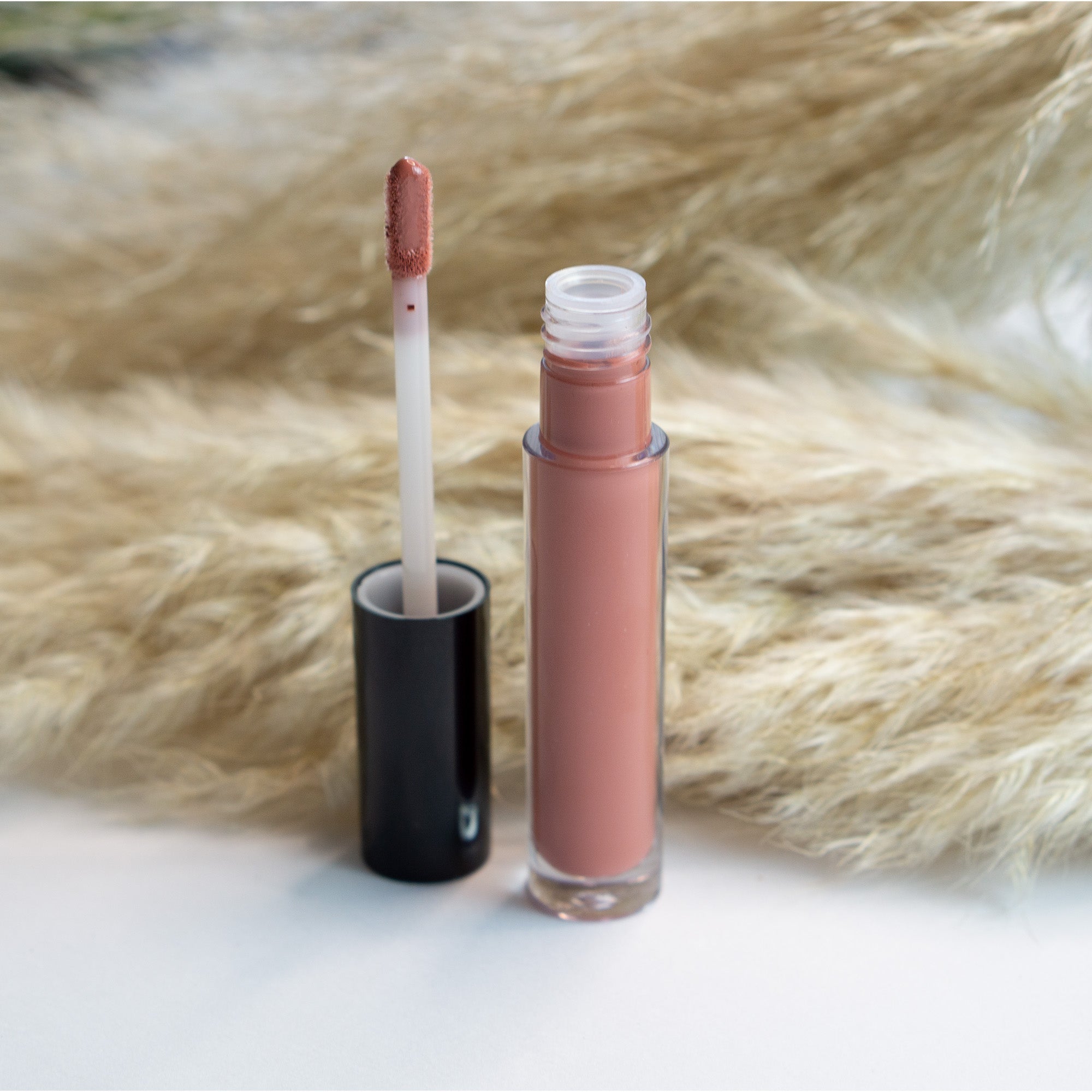 Chestnut Lip Gloss in a sleek tube with a doe-shaped applicator, showcasing its rich chestnut color and glossy finish.