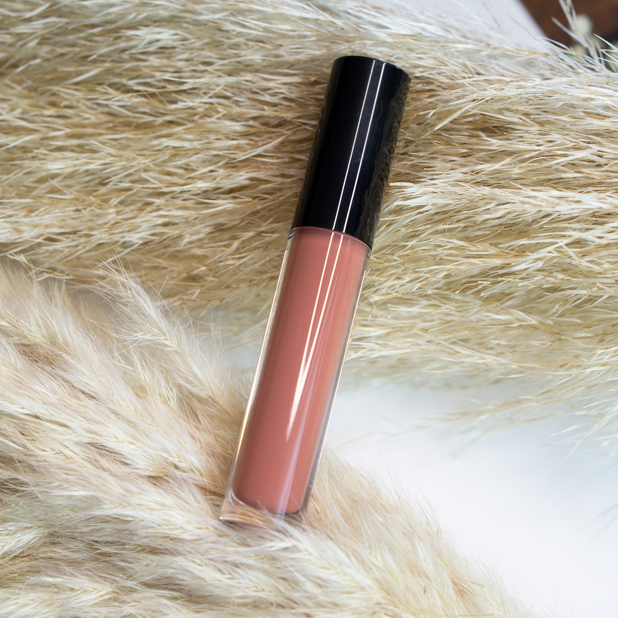 Chestnut Lip Gloss in a sleek tube with a doe-shaped applicator, showcasing its rich chestnut color and glossy finish.