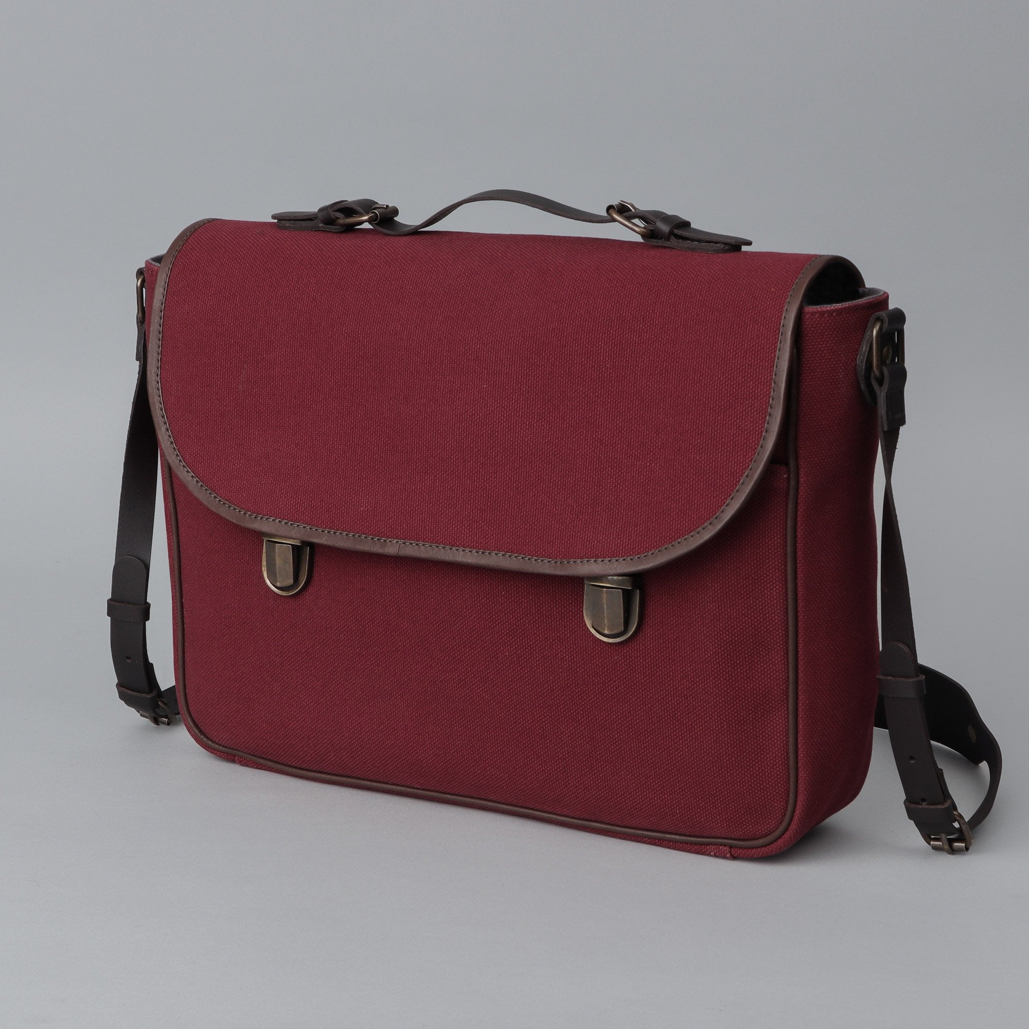 London Canvas Briefcase made from durable cotton canvas with leather straps, featuring a laptop compartment and multiple pockets.