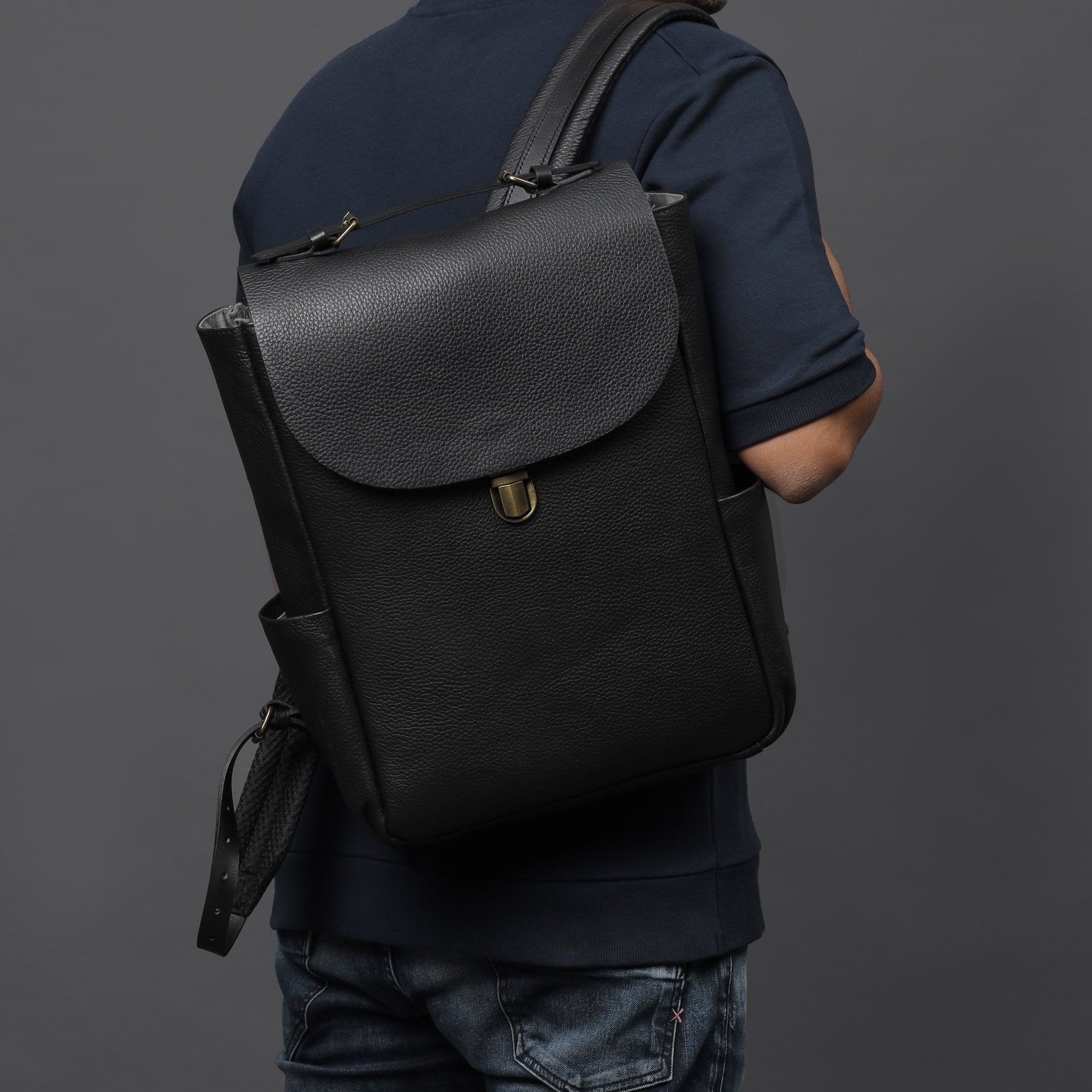 London Leather Backpack made from premium full grain leather, featuring multiple pockets, adjustable straps, and a spacious design for laptops.