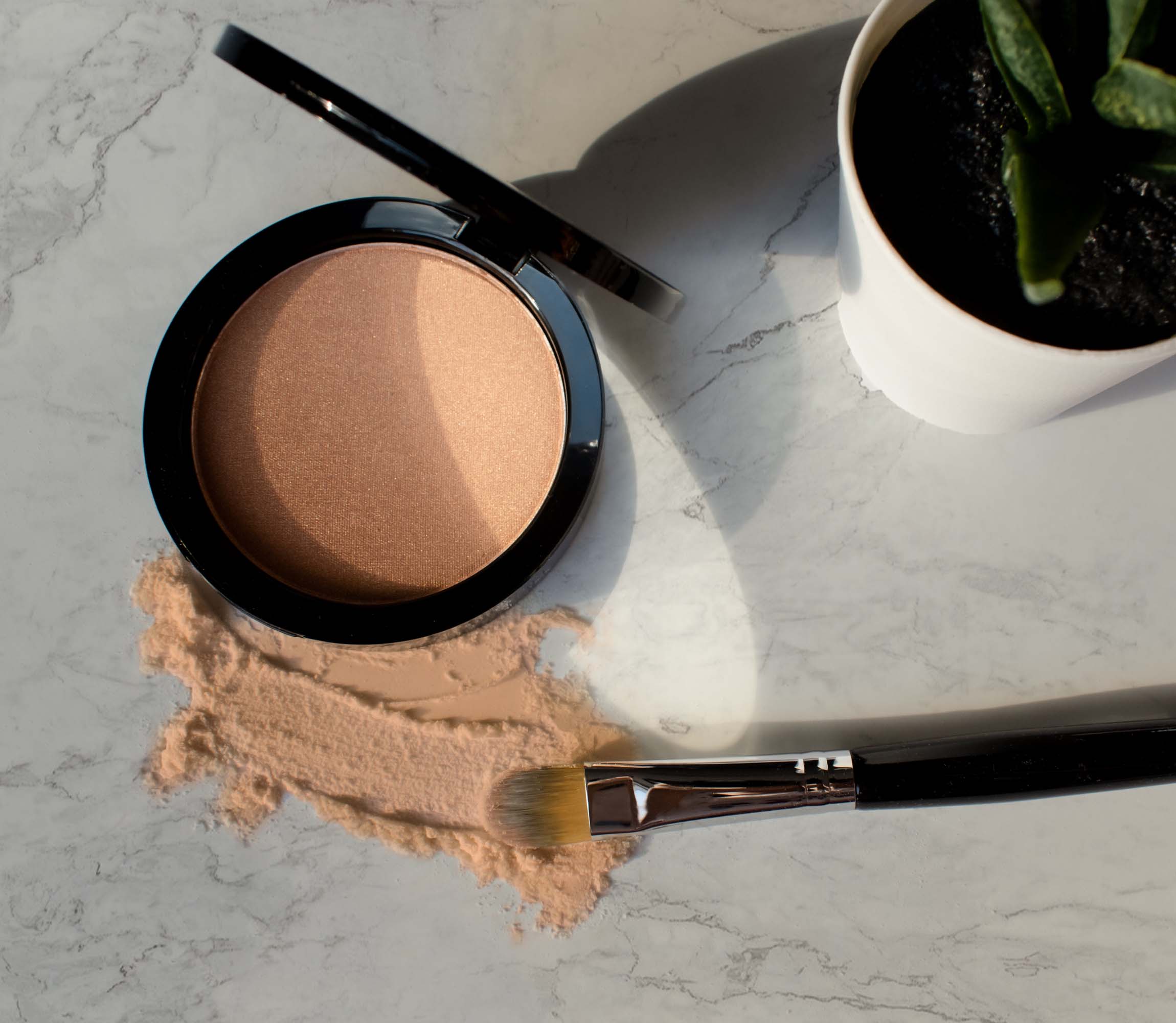 A compact of Luminizing Powder - Dewy showcasing its silky texture and shimmering finish, perfect for achieving a radiant glow.