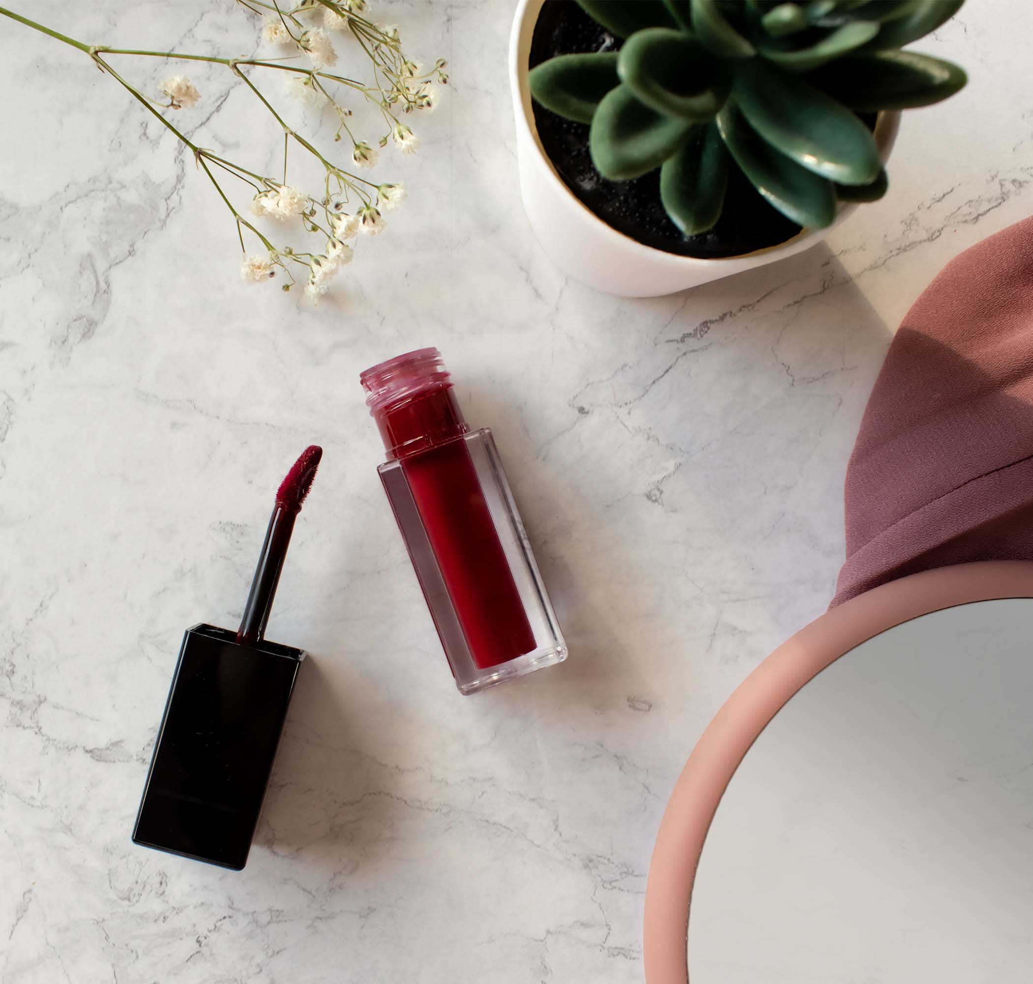 A close-up of the Matte Lip Stain in Dark Sienna, showcasing its sleek packaging and rich, dark color perfect for a bold lip look.