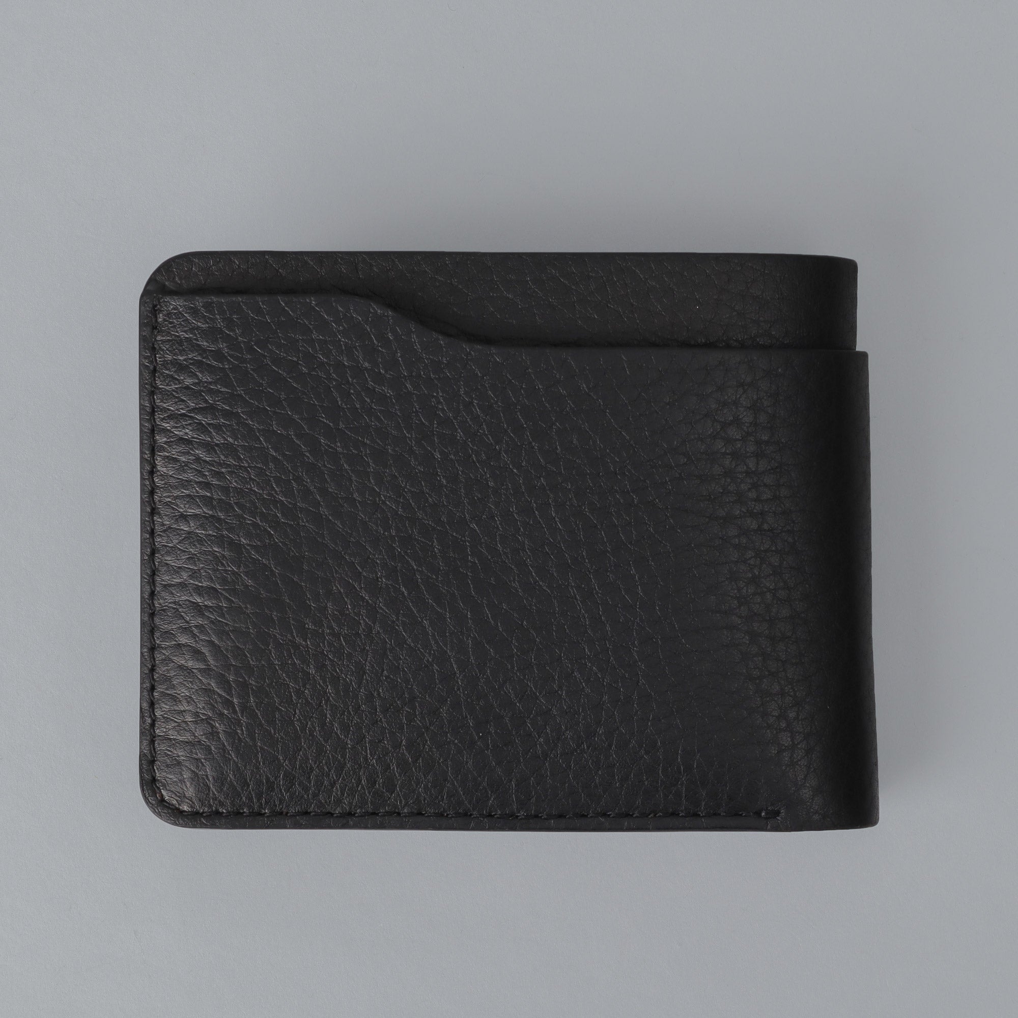 Max Wallet made from premium full grain leather with multiple pockets for cards and cash, featuring antique brass hardware.